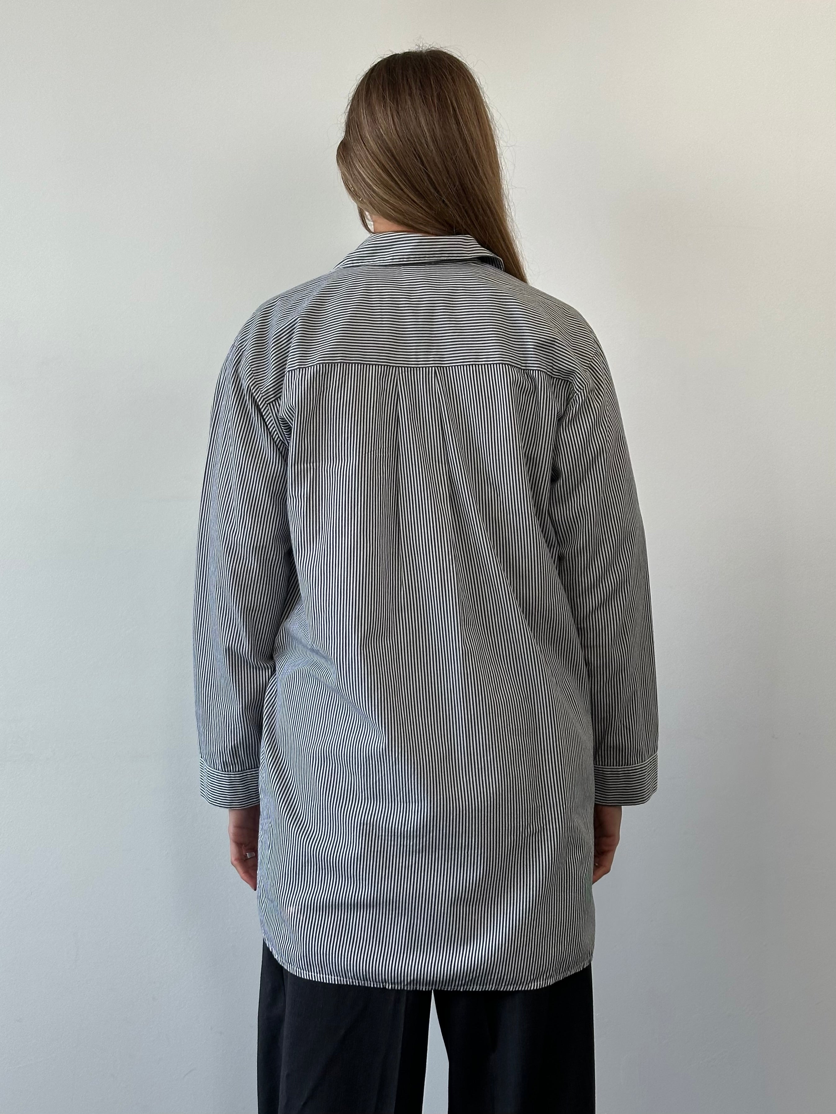 Calvin Klein pure cotton stripe logo shirt in XL laid flat, showcasing the classic design and brand logo on the chest.