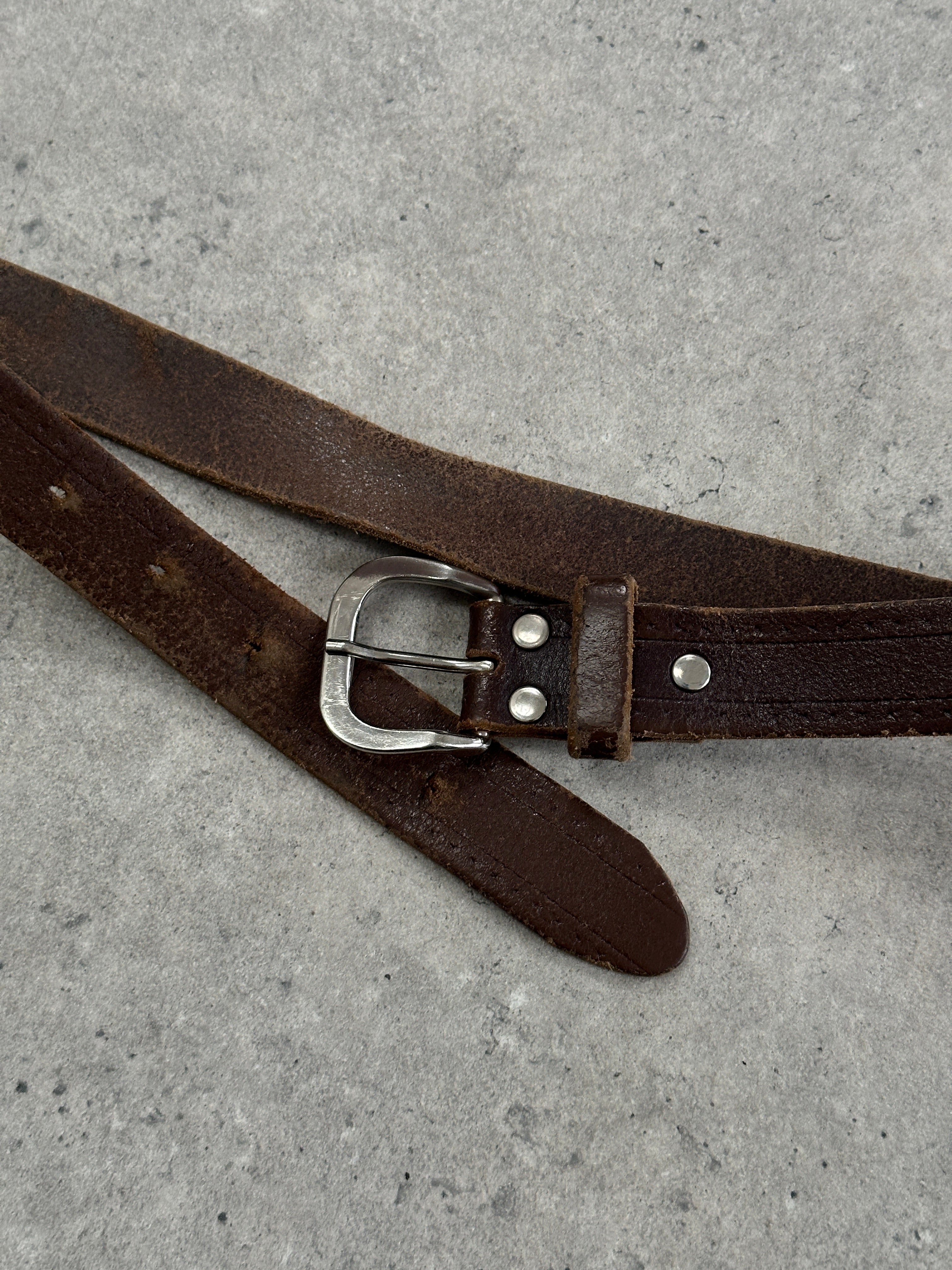 Vintage 1990s distressed slim leather belt with metal buckle, size W22-29 inches, stylish and retro accessory.