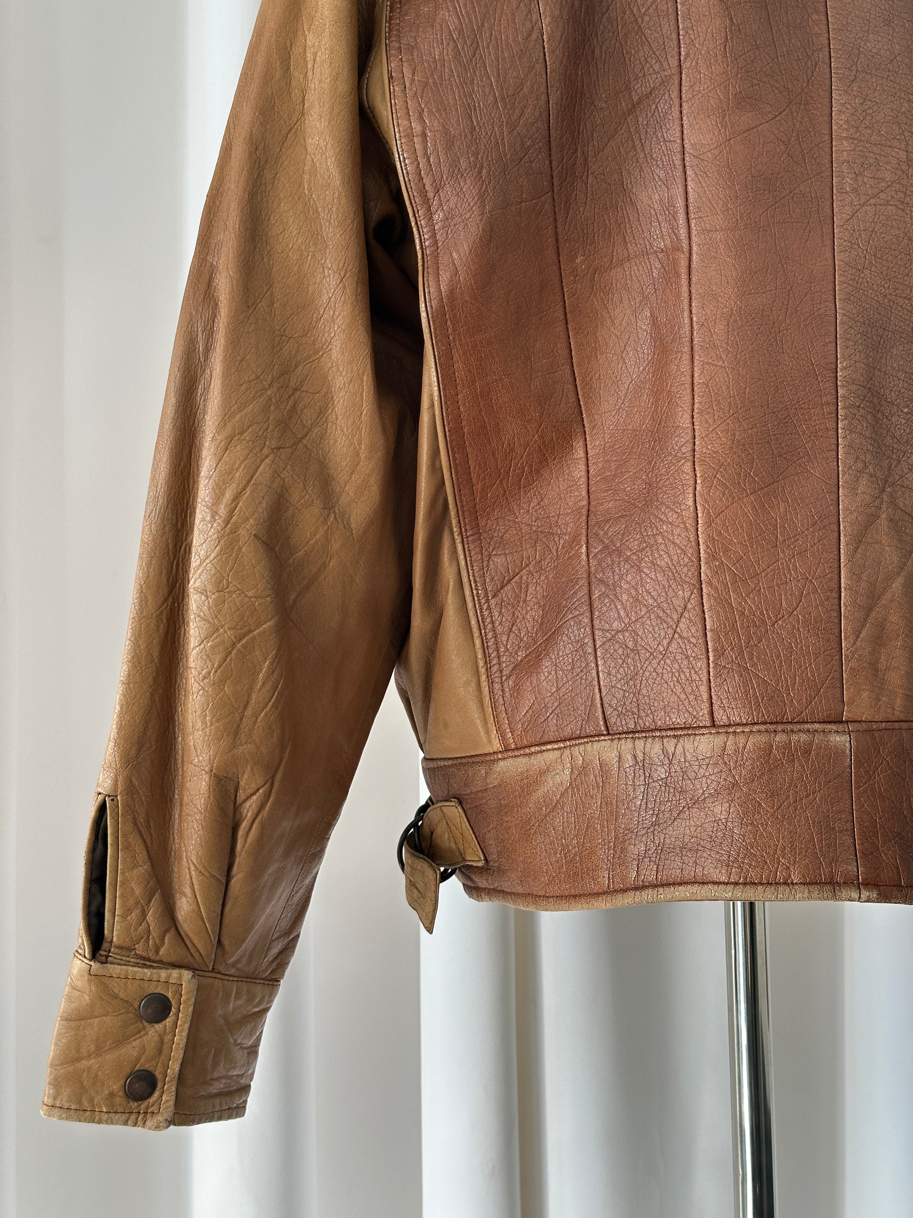 Vintage Italian 1980s leather bomber jacket with classic design, featuring a worn brown leather exterior and ribbed cuffs.