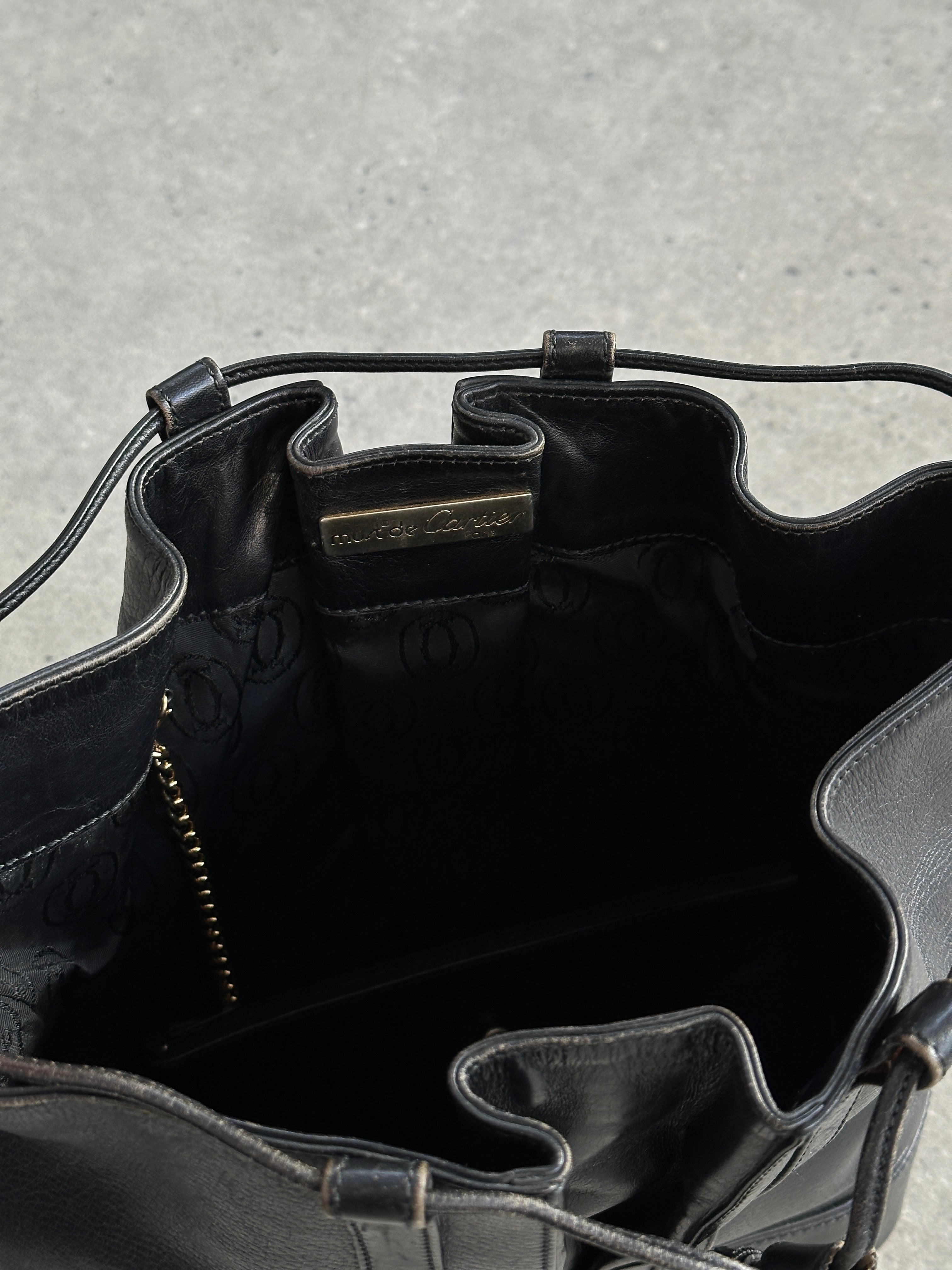 Cartier 1980s leather bucket bag with adjustable strap and classic design, featuring the brand's signature style and craftsmanship.
