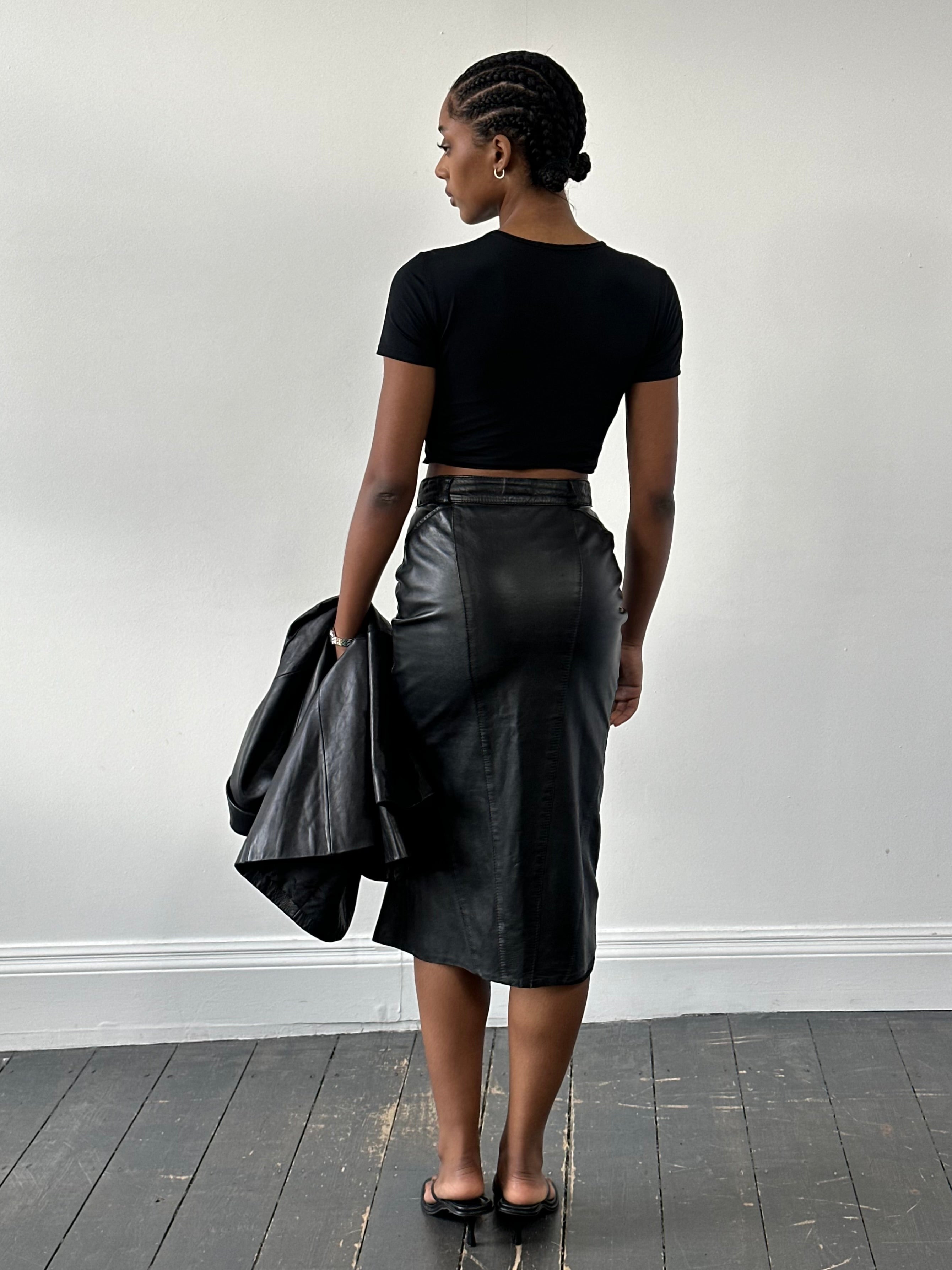 Vintage 1990s leather midi skirt with a high waist and classic A-line silhouette, displayed on a neutral background.