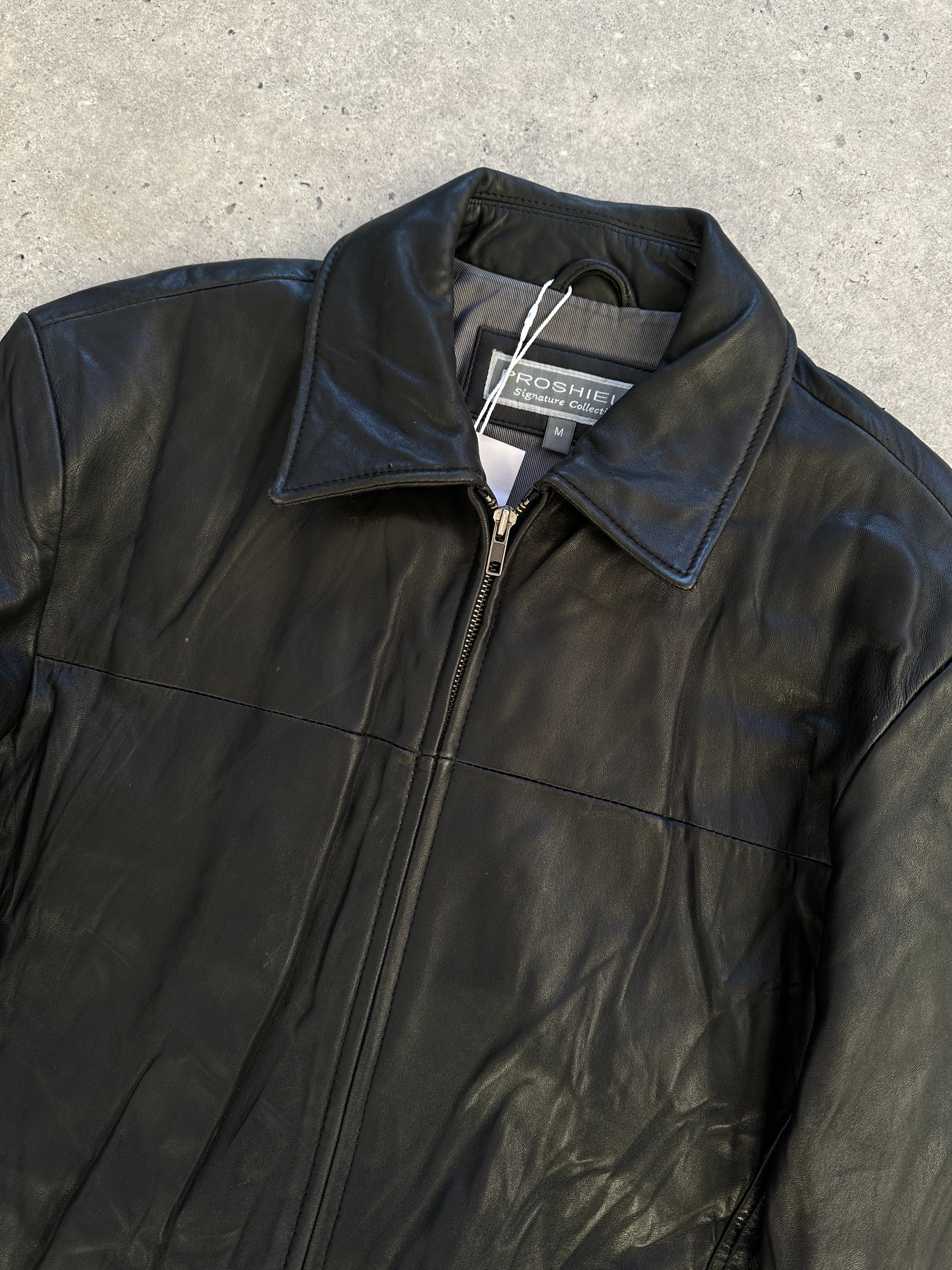 Vintage minimal leather jacket in size M/L, showcasing classic design with sleek leather and clean lines.