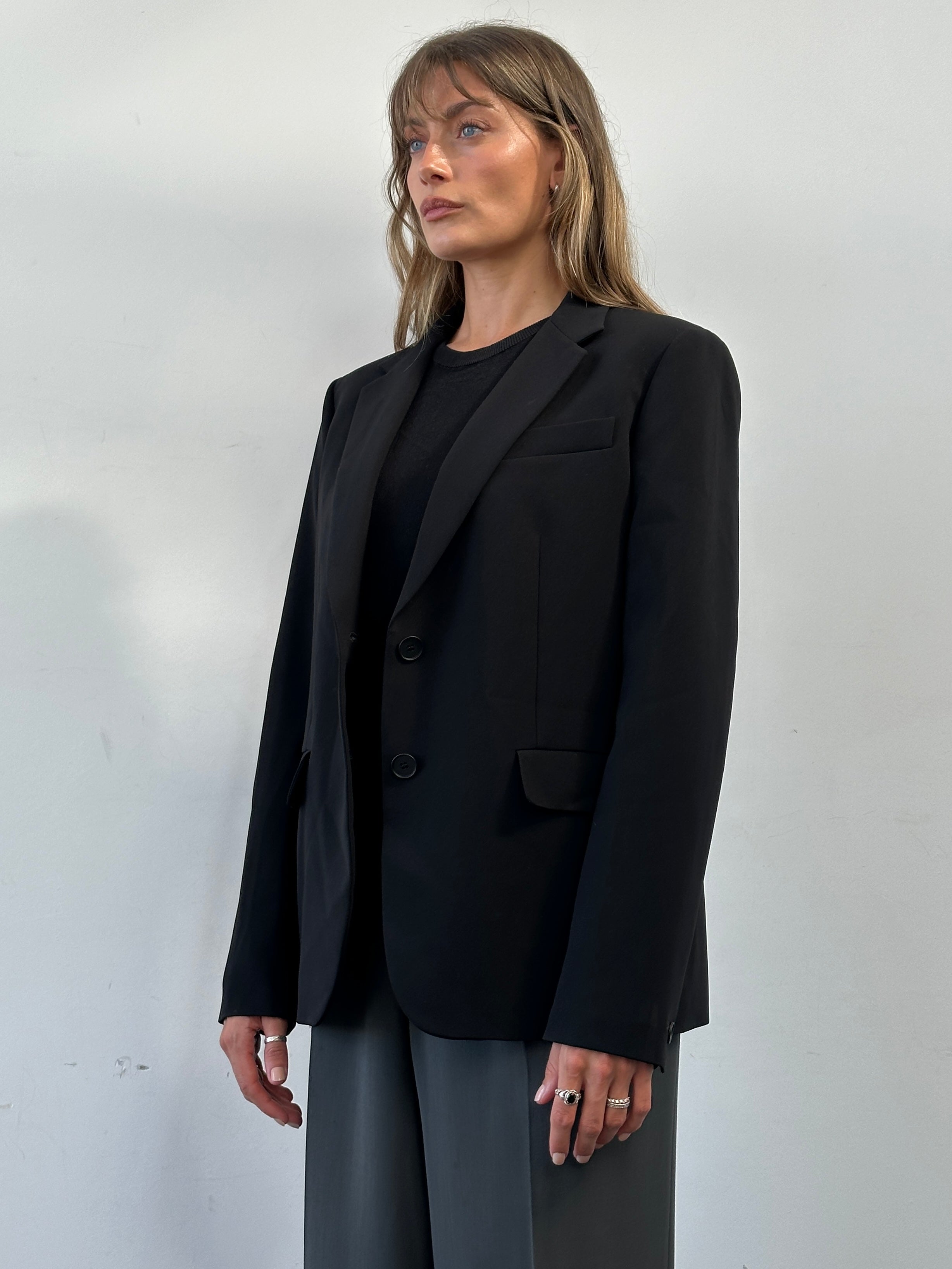 Max Mara Studio single-breasted blazer in black, tailored fit, with notch lapel and front buttons, displayed on a hanger.