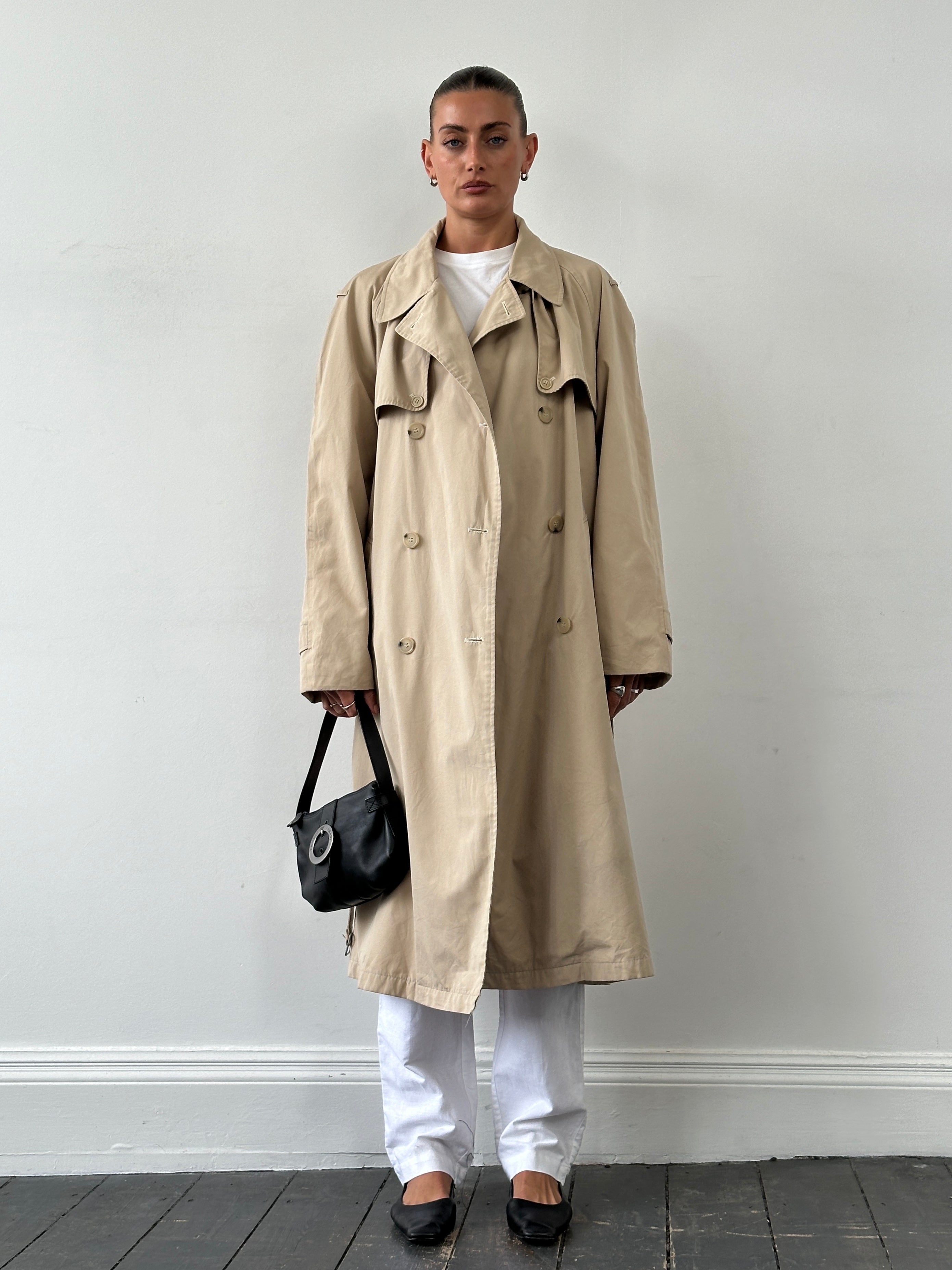 Yves Saint Laurent 70s-style cotton double-breasted belted trench coat in XL, beige color, displayed hanging on a wooden hanger.