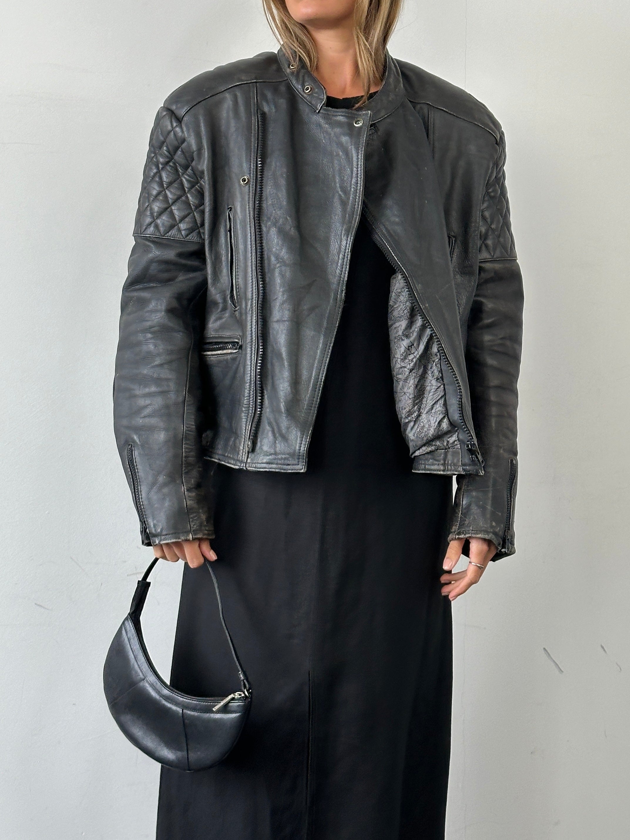 Vintage distressed leather motorcycle jacket in size L/XL featuring rugged design and classic style.