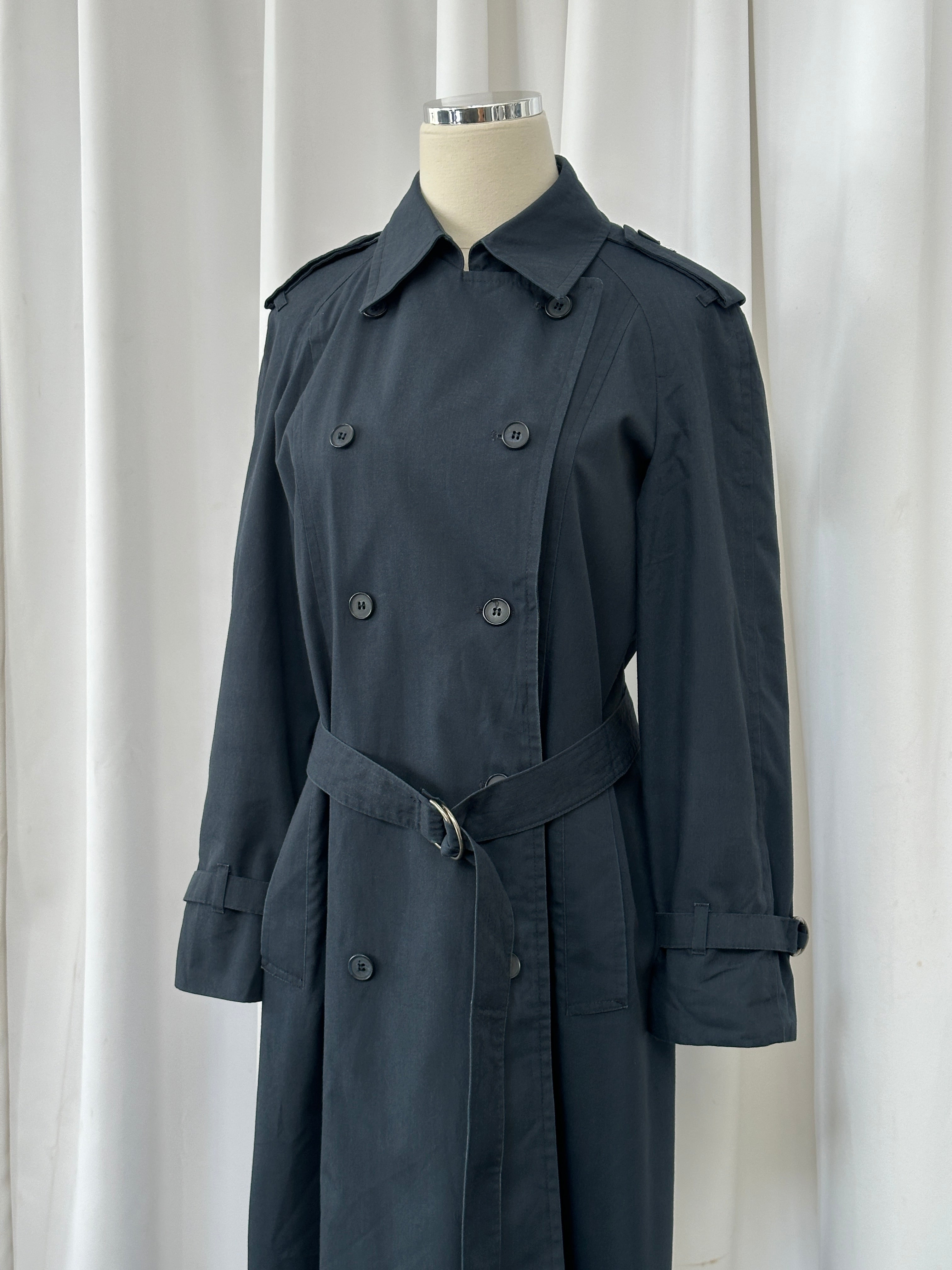 London Fog 1980s double-breasted cotton trench coat in size S, shown hanging with classic beige color and belted waist.