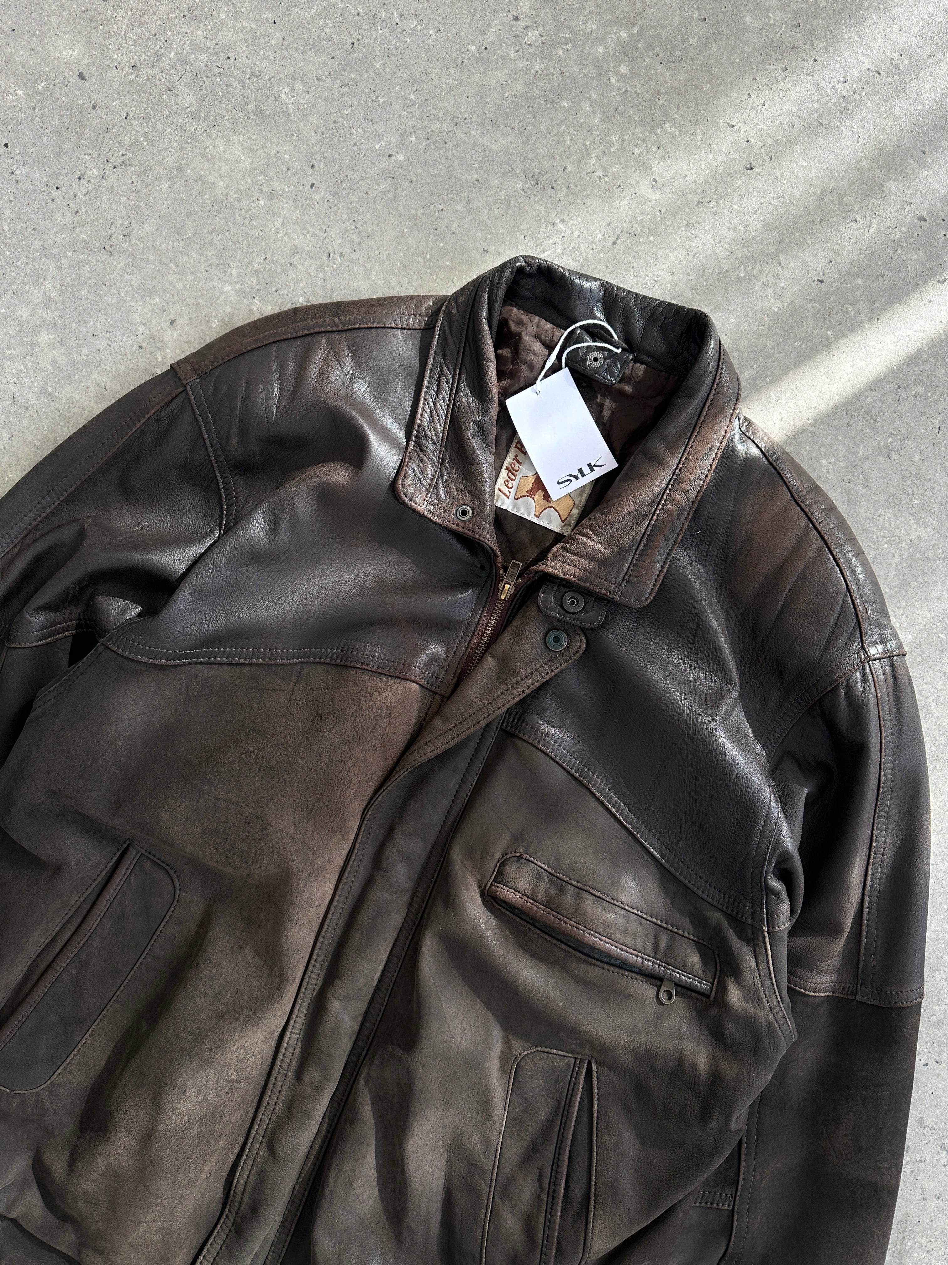 Vintage aged leather bomber jacket in size large, featuring a classic design with distressed leather and ribbed cuffs.