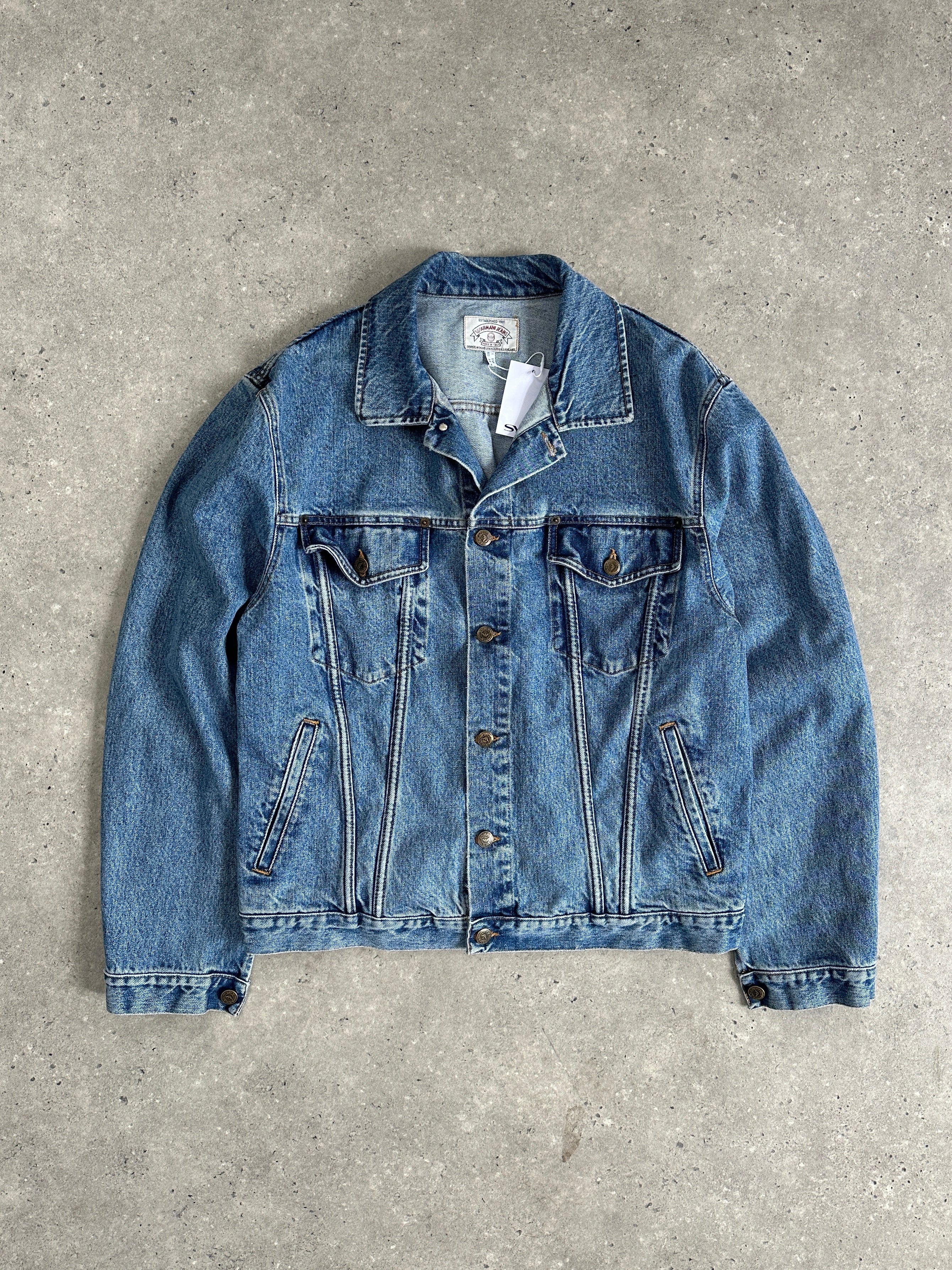 Armani Jeans mid wash denim jacket in size L, featuring classic fit and button closure, displayed on a hanger against a neutral background.