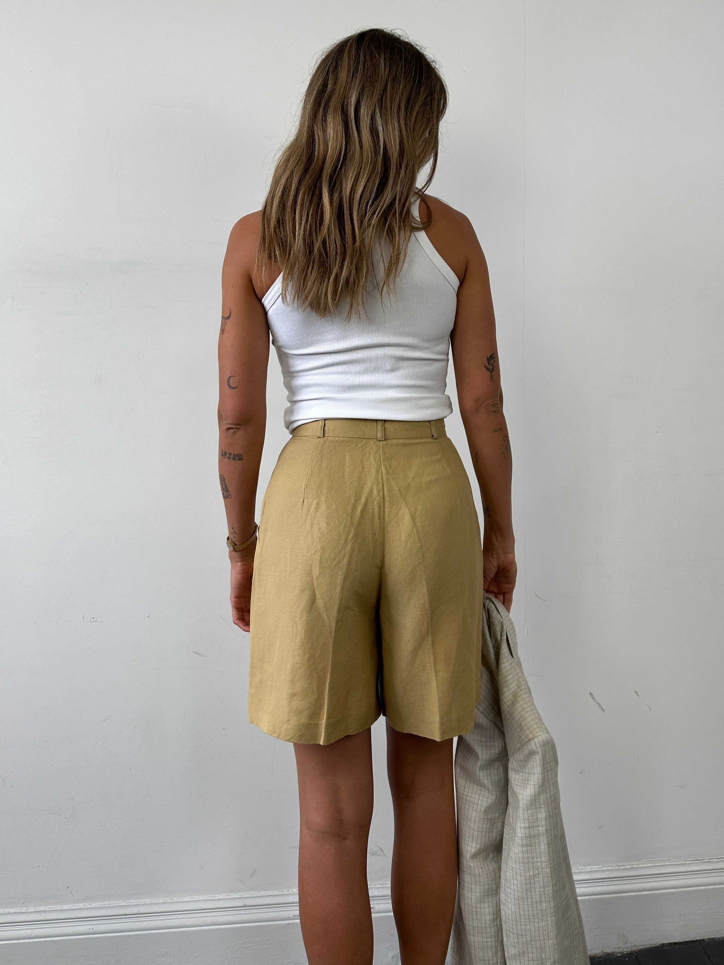 Vintage linen pleated wide leg shorts in size W26, featuring a relaxed fit and classic design for a retro summer look.