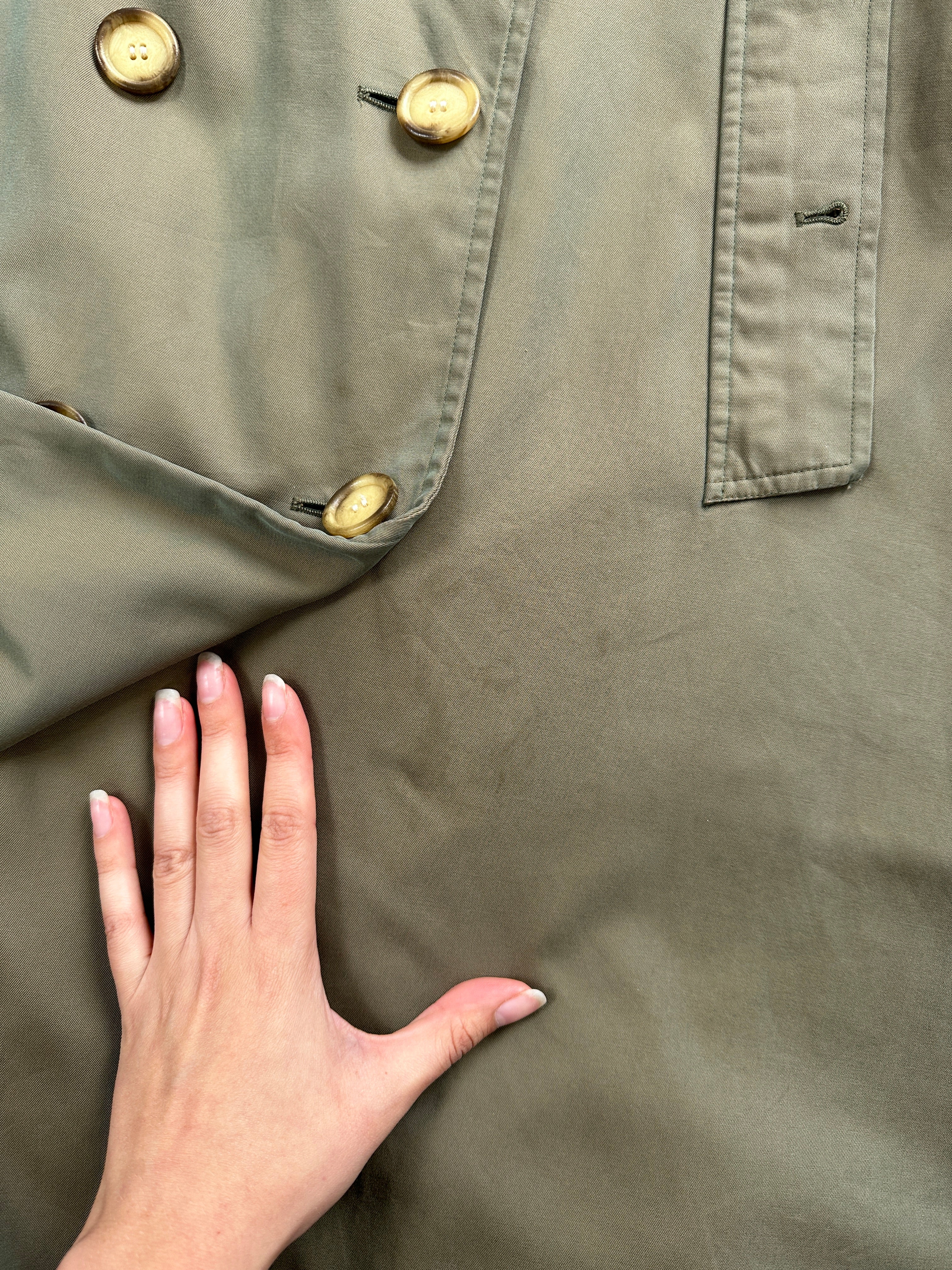 Yves Saint Laurent Rive Gauche 1980s double-breasted trench coat, beige fabric, classic collar, and belted waist on model.