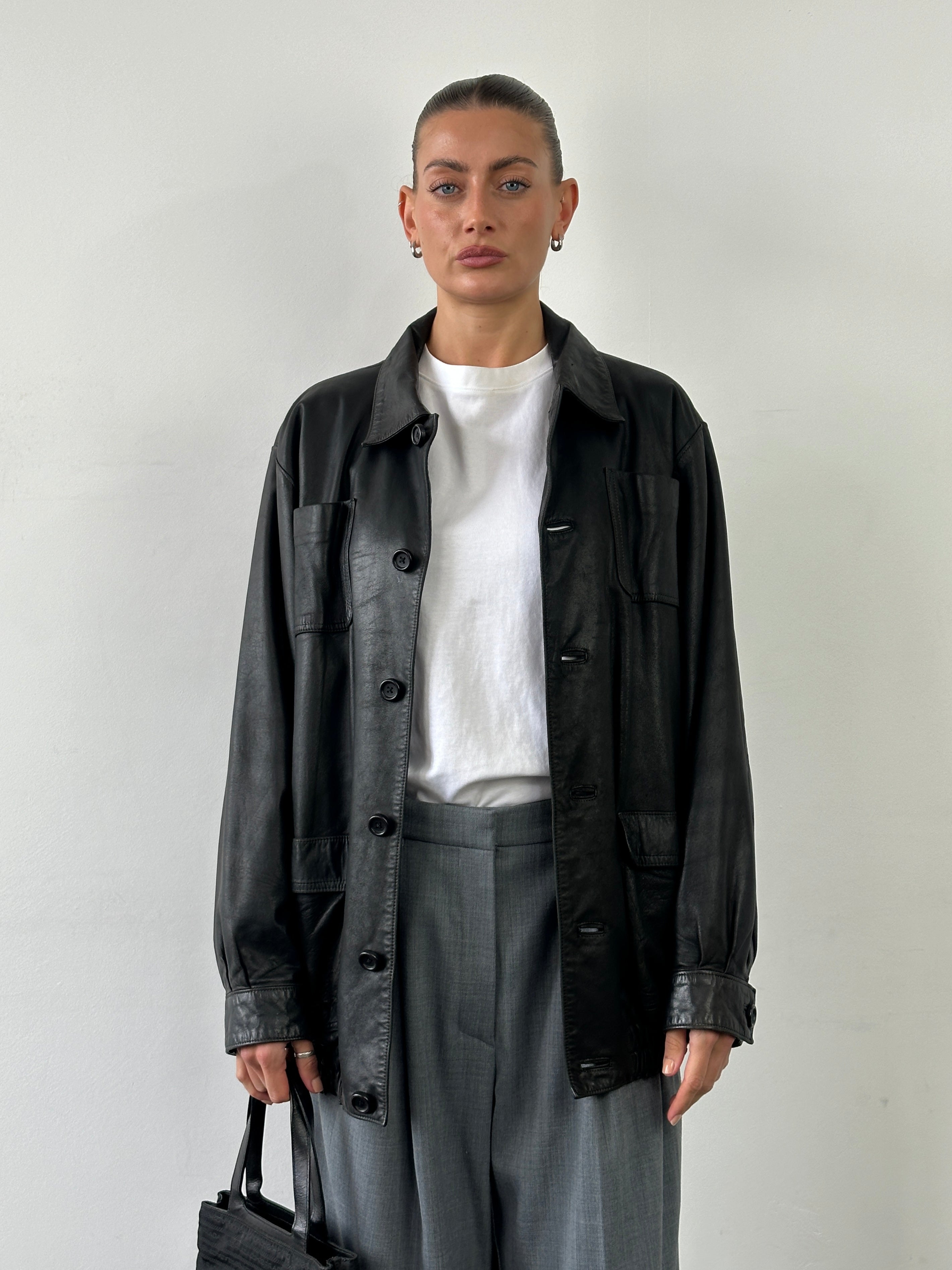 Vintage leather minimal bomber jacket in XL, featuring classic design and smooth leather material, displayed on a hanger.