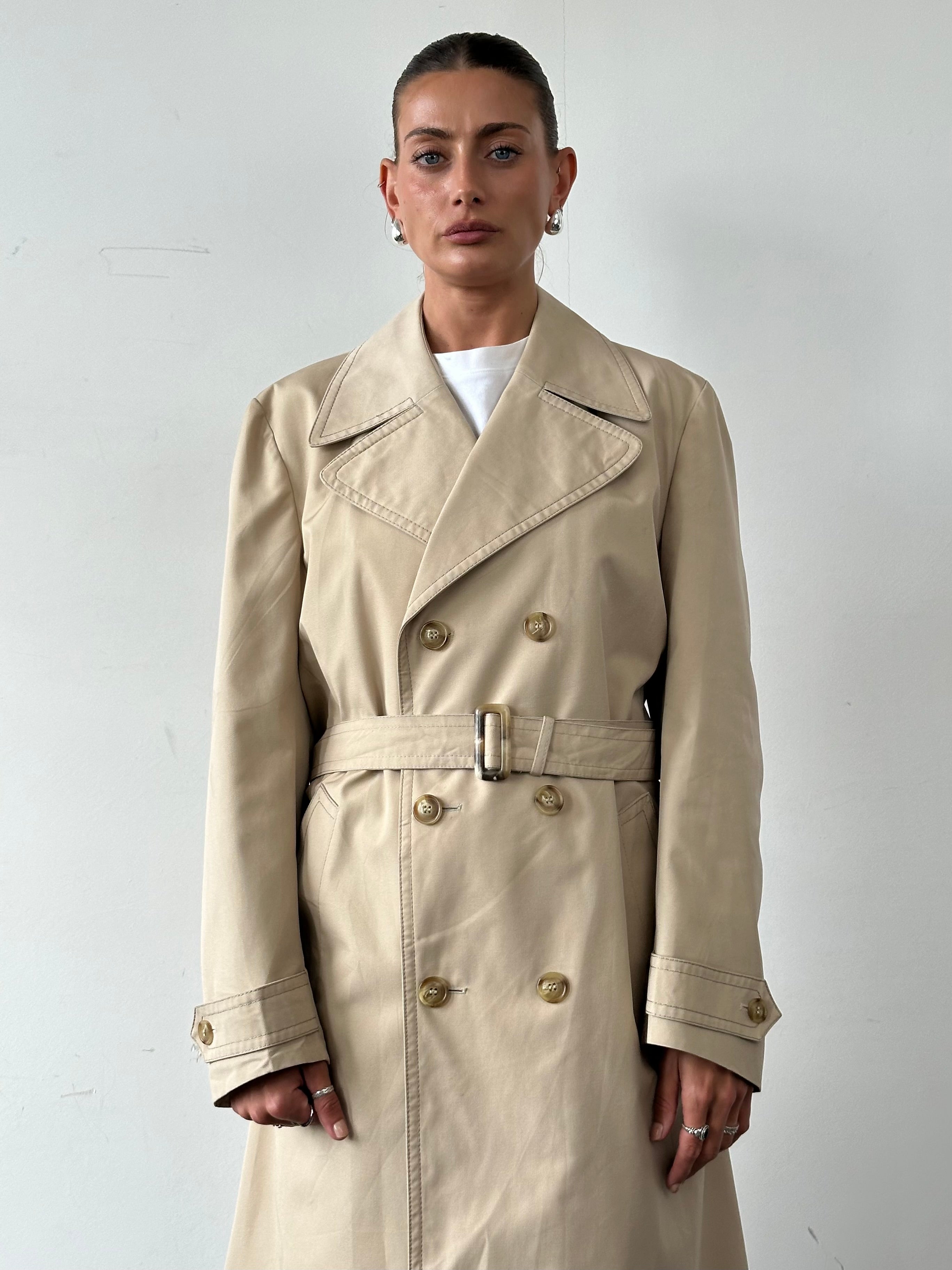 Vintage double-breasted belted trench coat in classic style, featuring a tailored fit and timeless design.