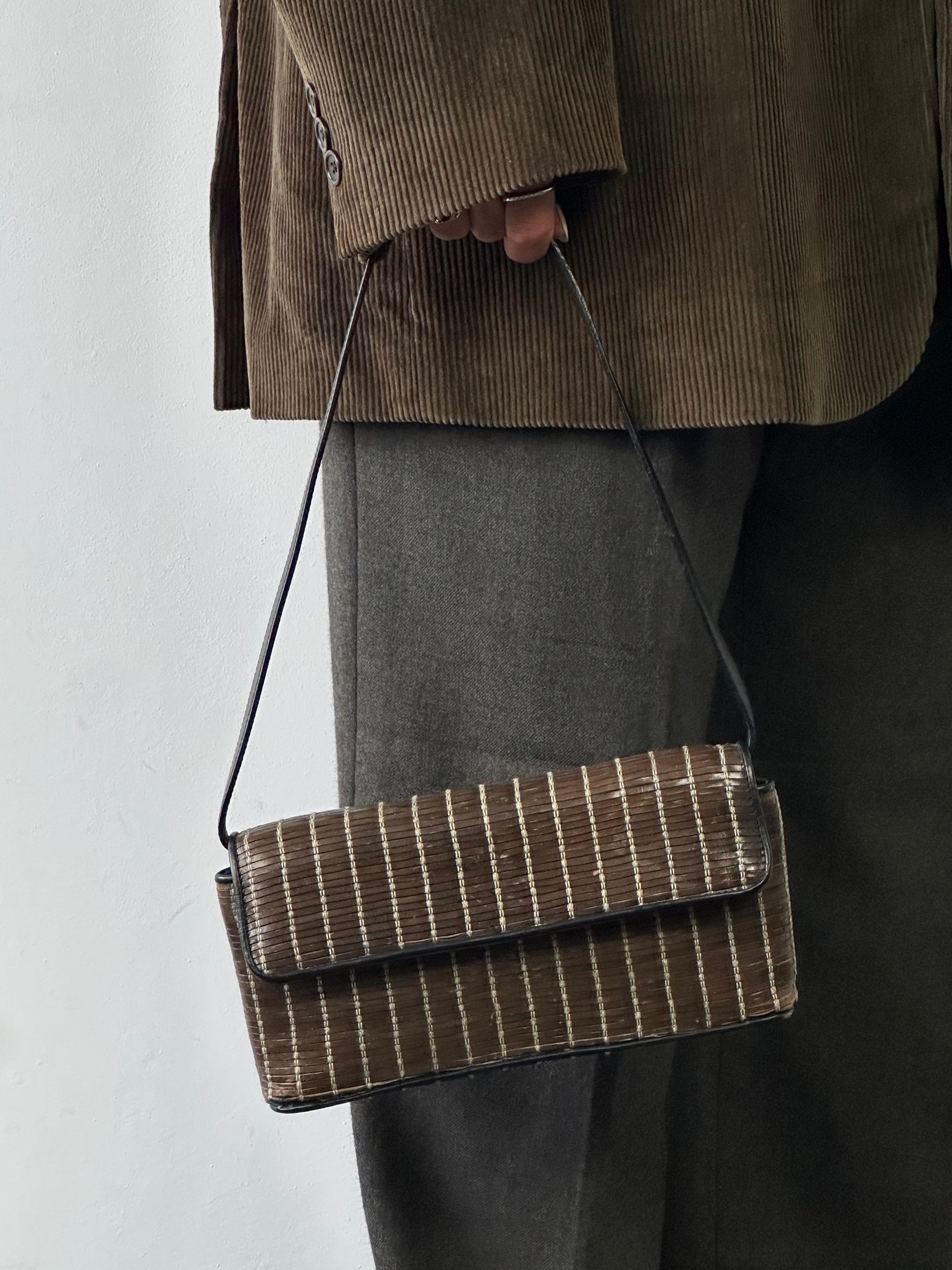 Giorgio Armani leather handbag with sleek design, featuring top handles and elegant stitching, displayed on a neutral background.