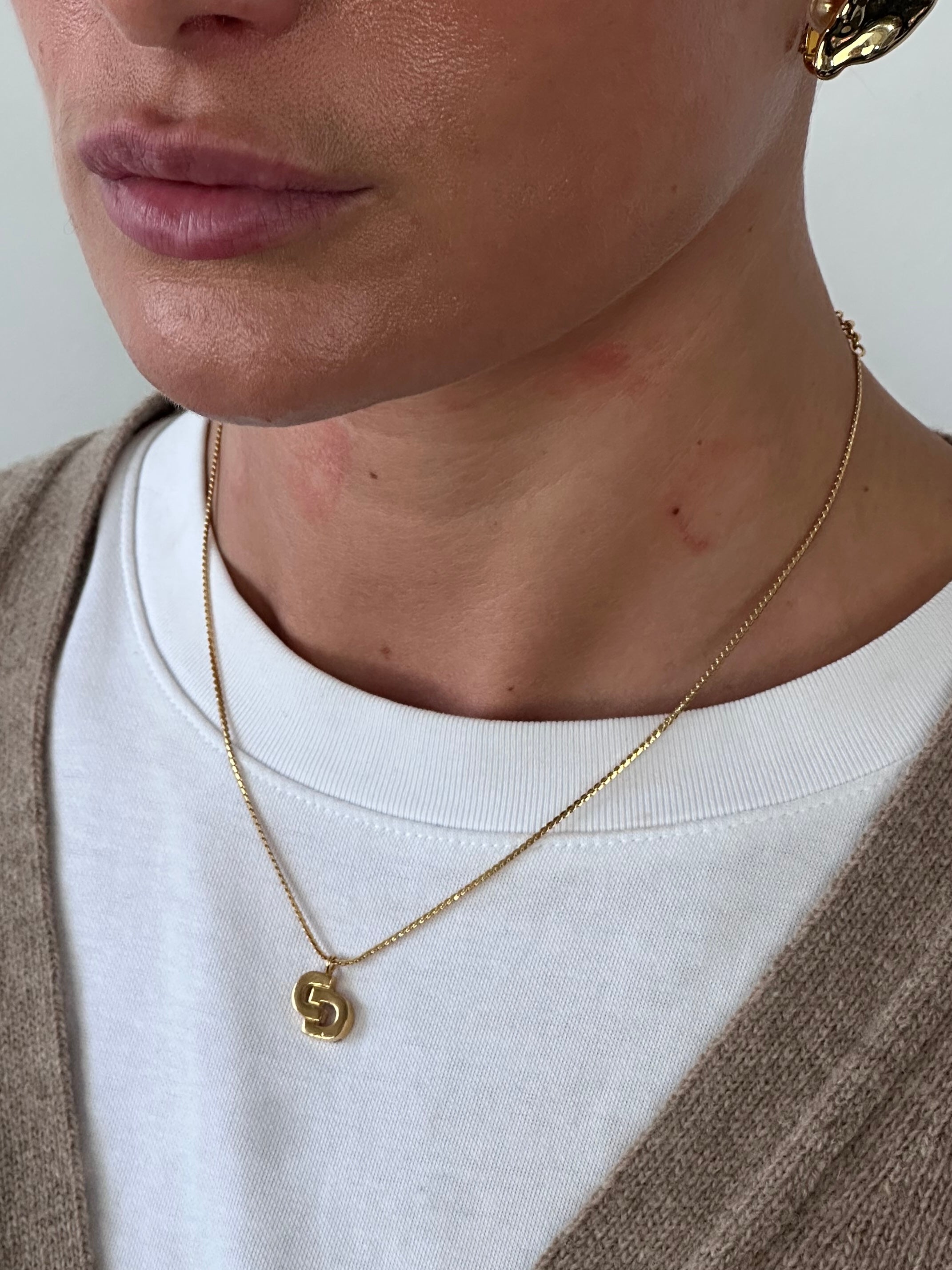 Christian Dior 16-inch gold plated logo pendant necklace with a sleek pendant and chain, showcasing elegant jewelry design.