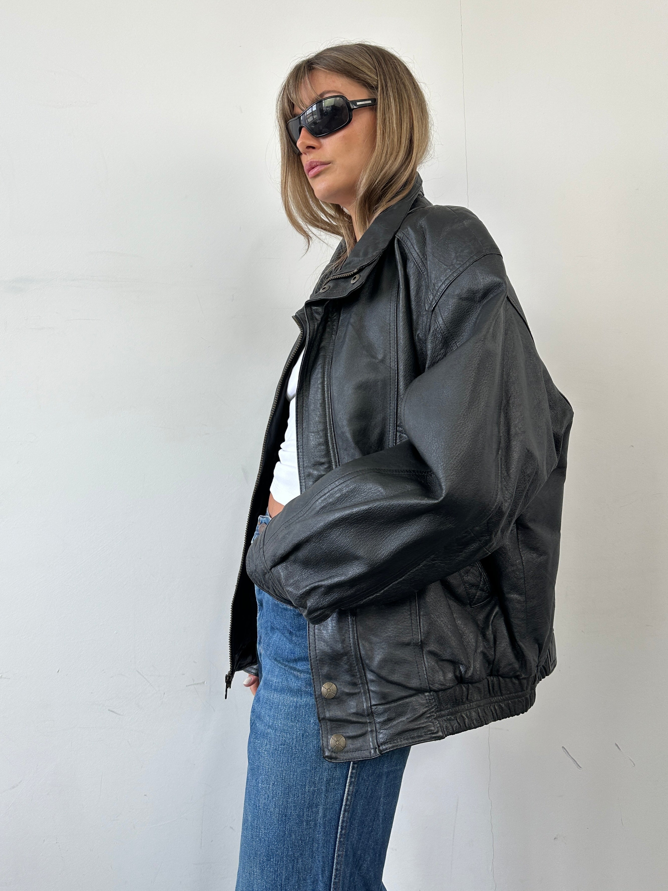 Vintage leather bomber jacket in size XL, featuring classic design with a smooth brown finish and ribbed cuffs and collar.