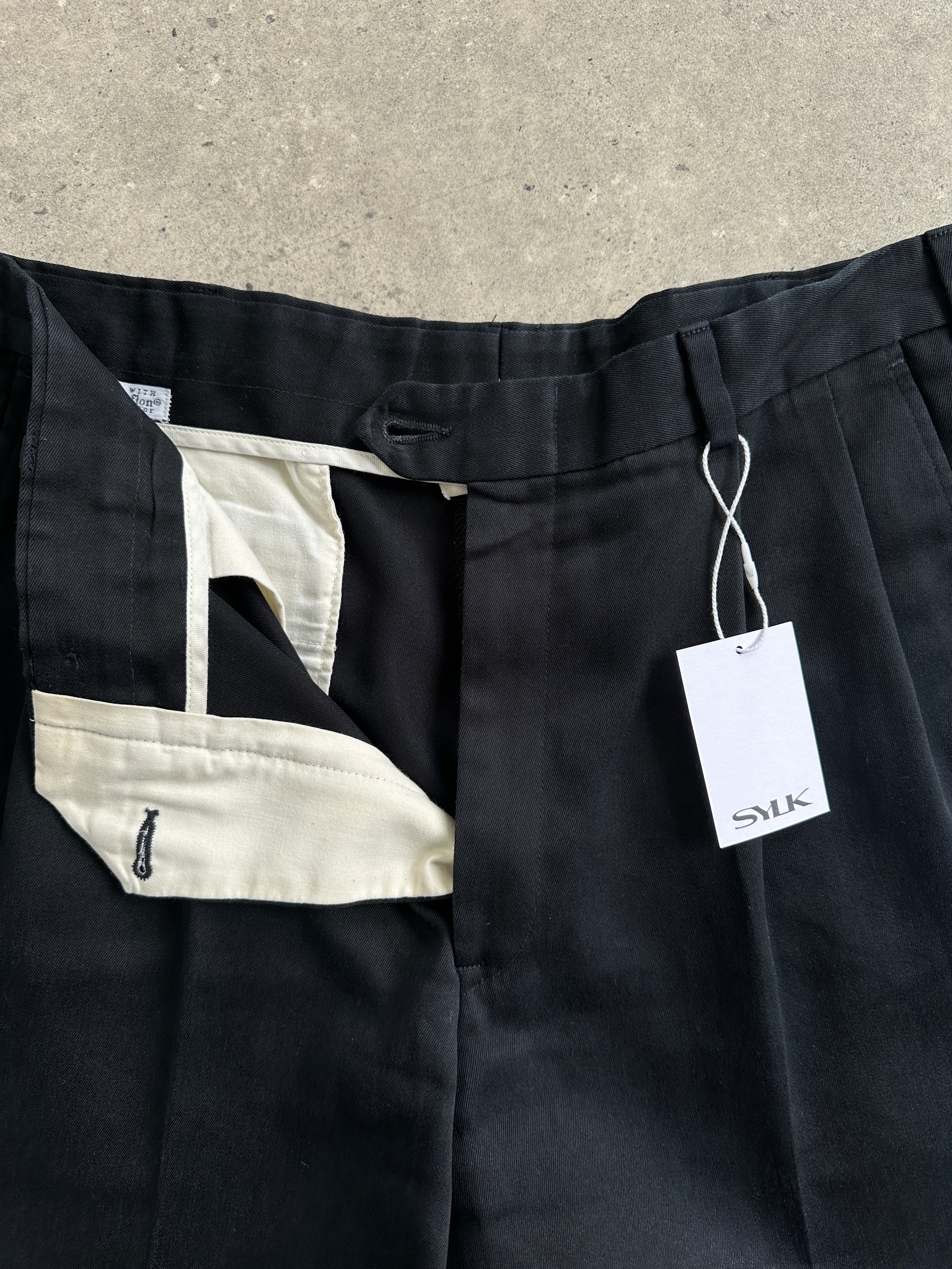 Vintage high waisted pleated trousers made from Pima cotton with a classic fit, shown in a natural beige color.