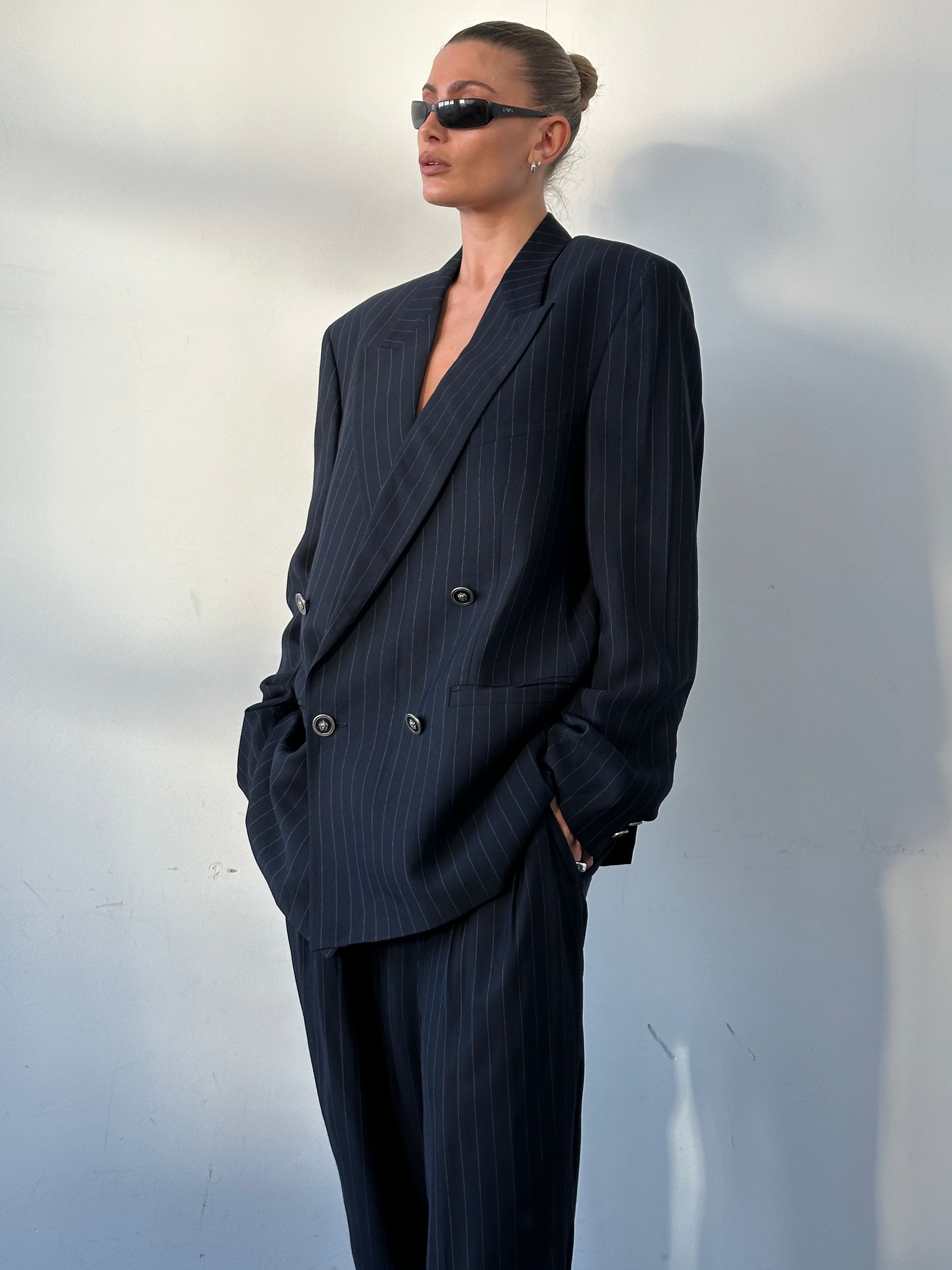 Versace Versus 1990s pinstripe double-breasted suit in navy with tailored lapels, displayed on a mannequin.