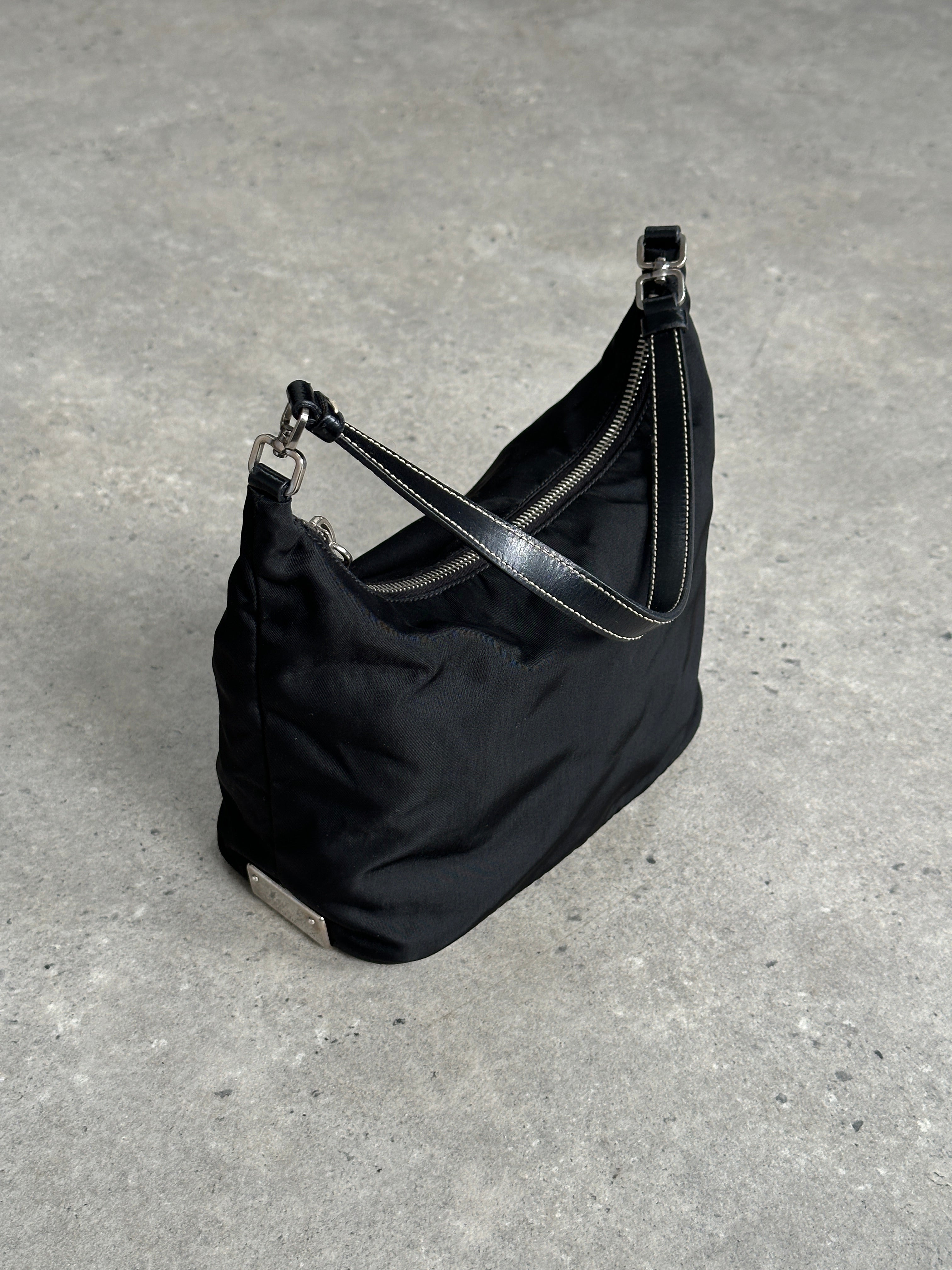 Prada nylon shoulder bag with chrome logo hardware, featuring a sleek design and adjustable strap.