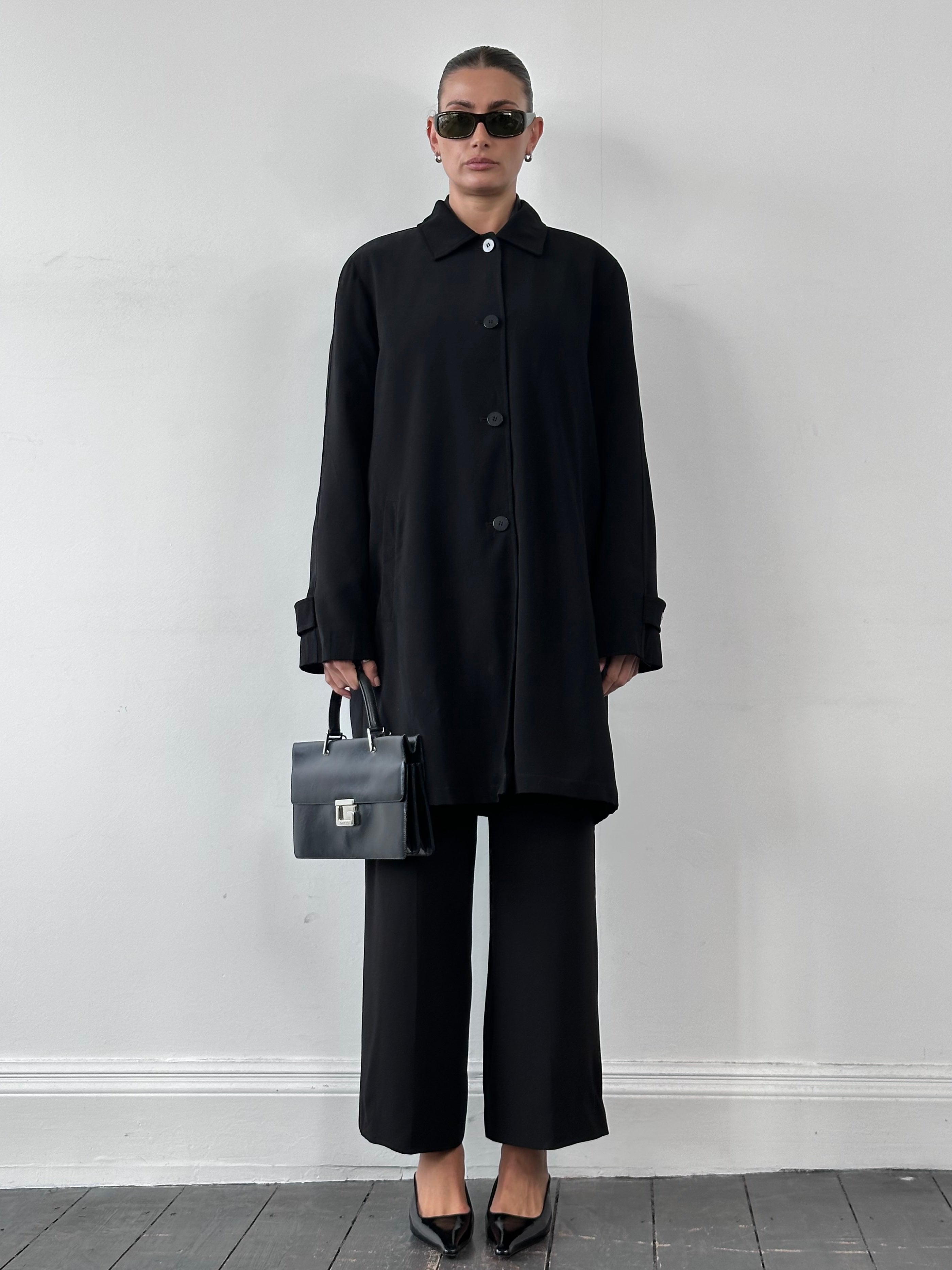 London Fog XL single-breasted trench coat hanging on a wooden hanger, showcasing classic beige design and tailored fit.