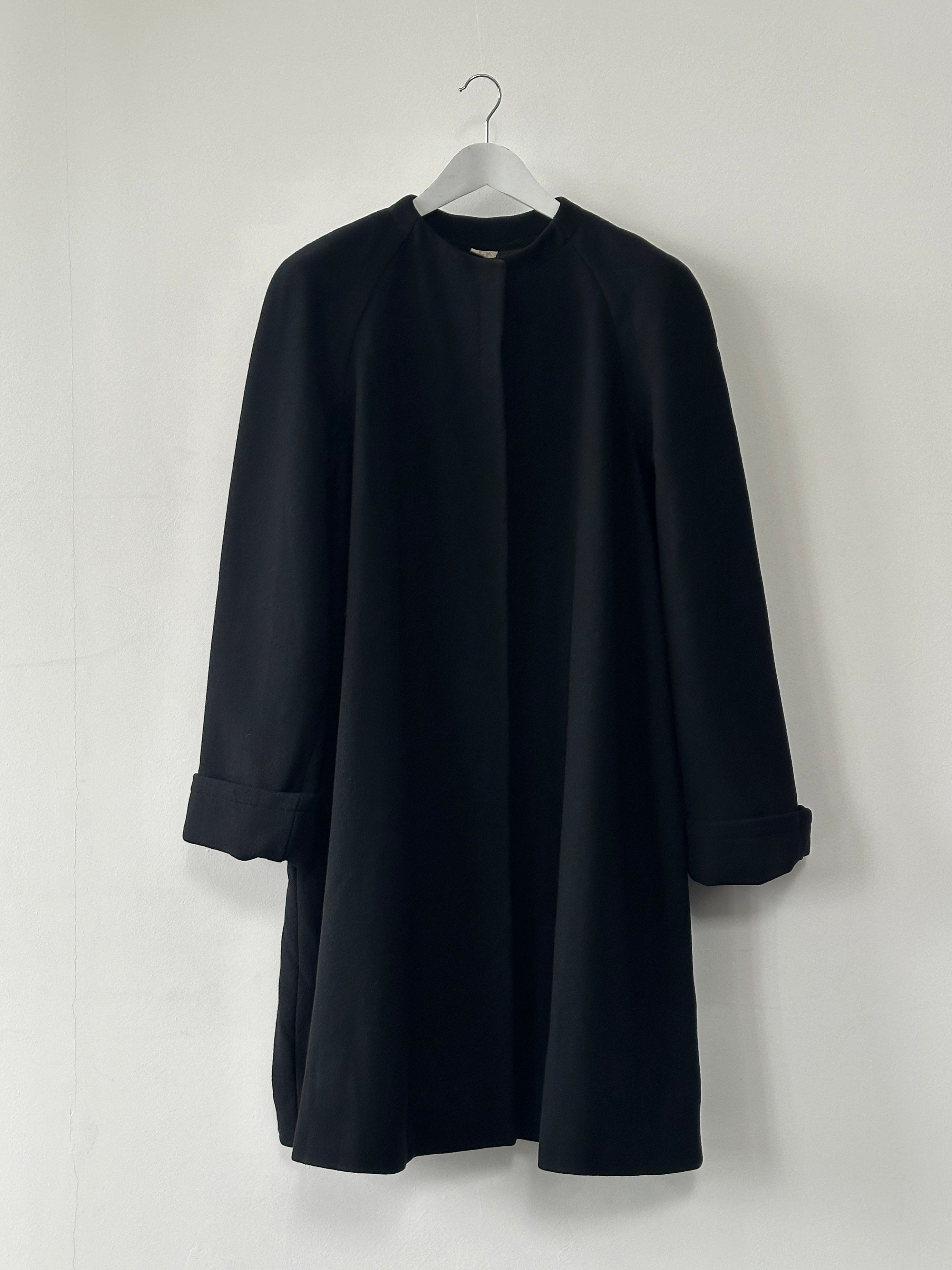 Gianfranco Ferre pure wool A-line coat in XL with minimal design and collarless style, shown hanging on a clothing rack.