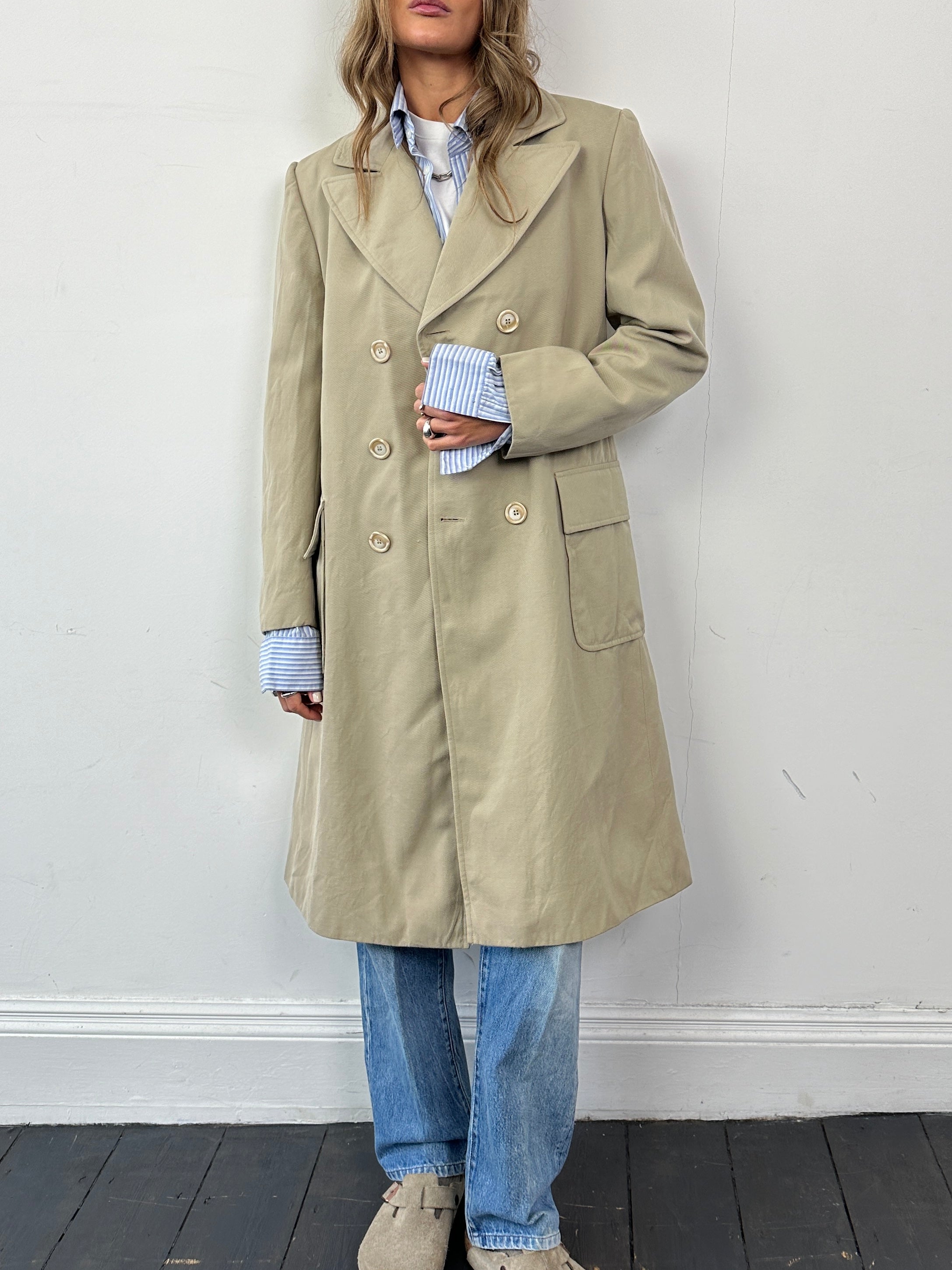 Vintage Italian double-breasted pure wool trench coat in classic style, shown on a hanger in a natural fabric setting.