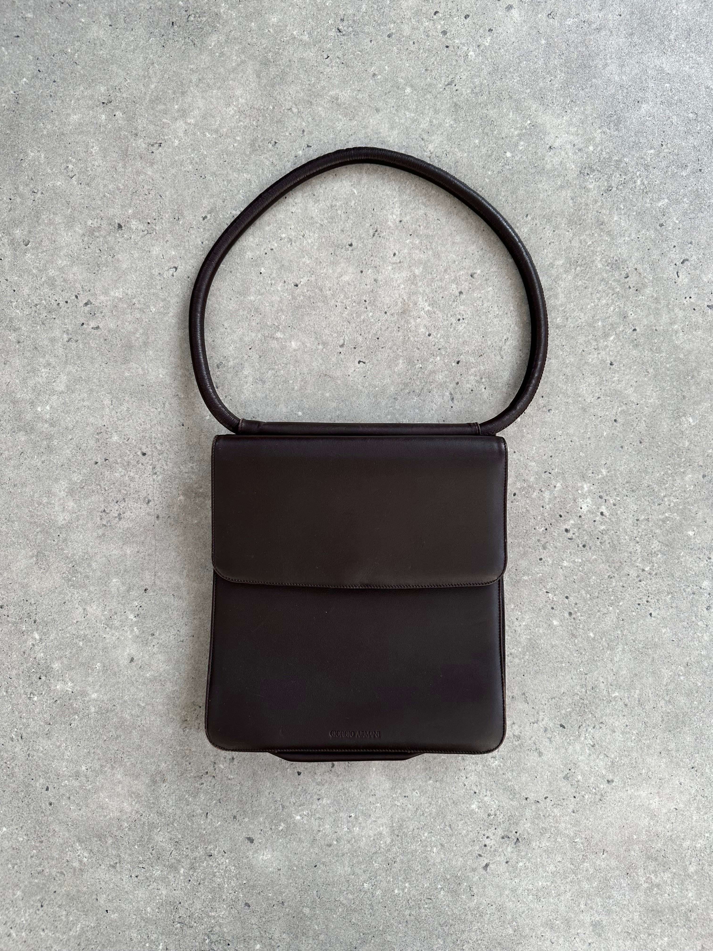 Giorgio Armani Le Collezioni leather shoulder bag with sleek design and top handle, featuring subtle branding and elegant craftsmanship.