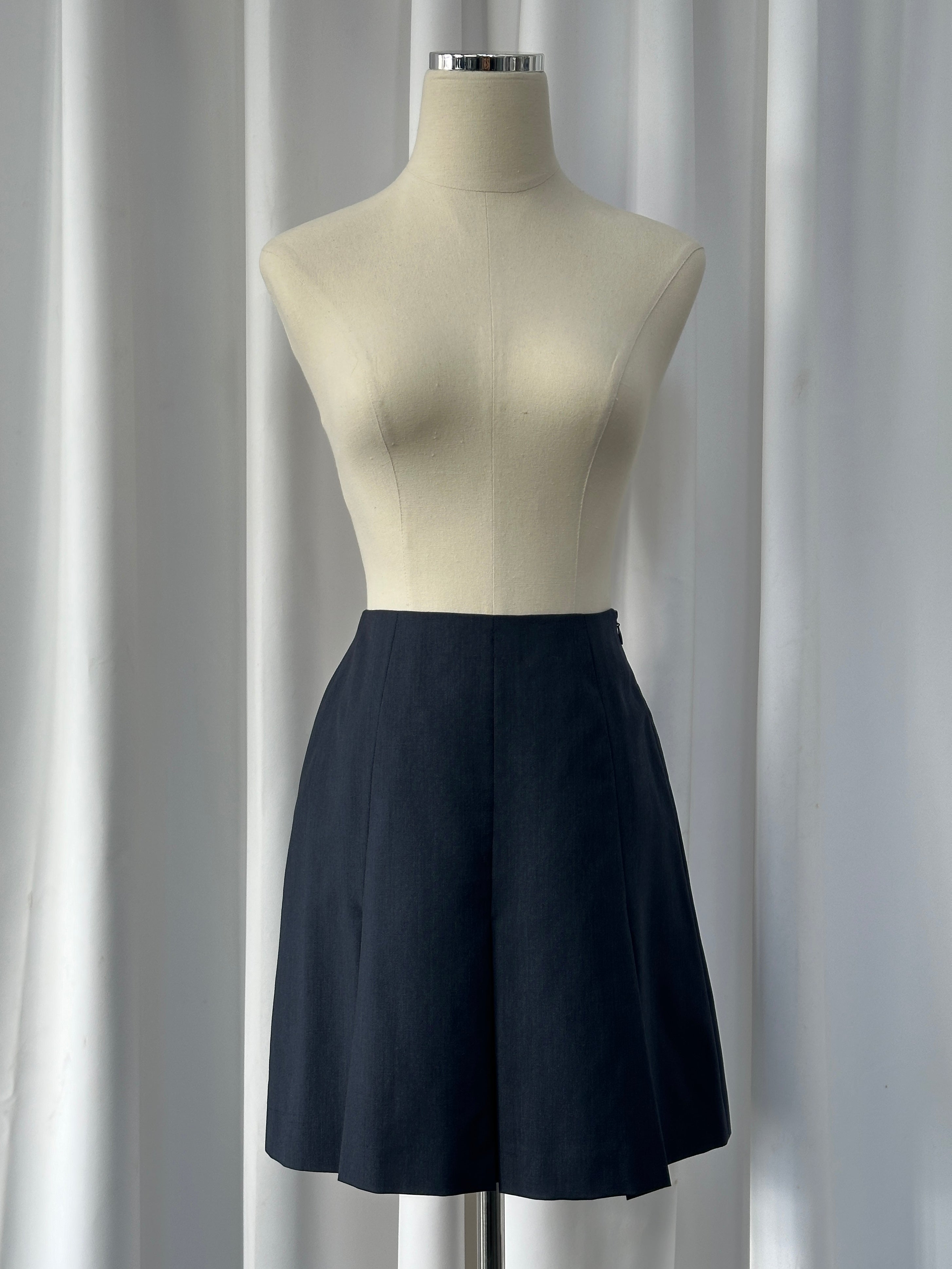 Vintage Italian 1990s pure merino wool pleated mini skirt, size W24, featuring classic pleats and a timeless design.