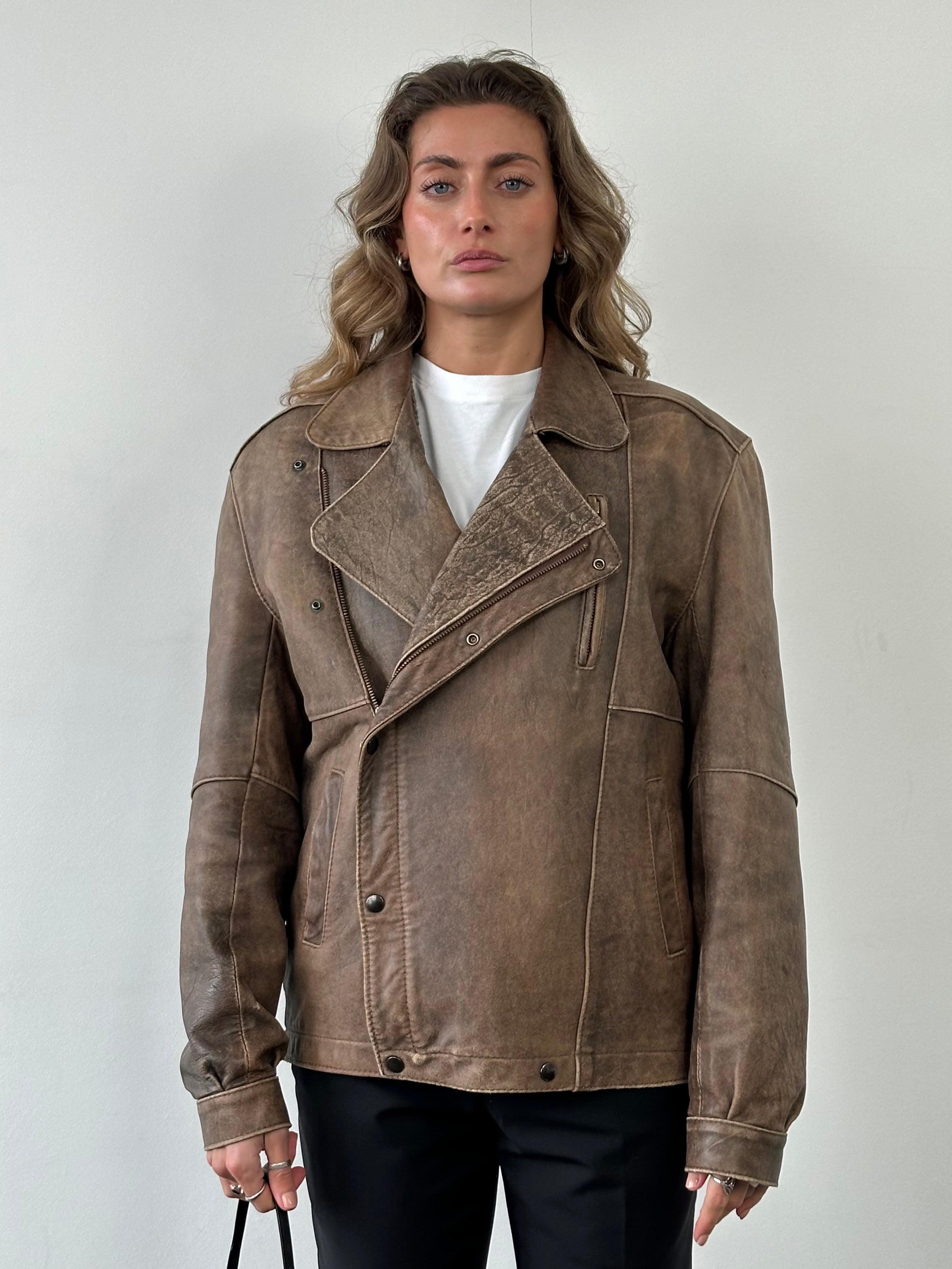 Vintage British aged leather biker jacket in size M/L, featuring classic rugged design and authentic distressed leather finish.
