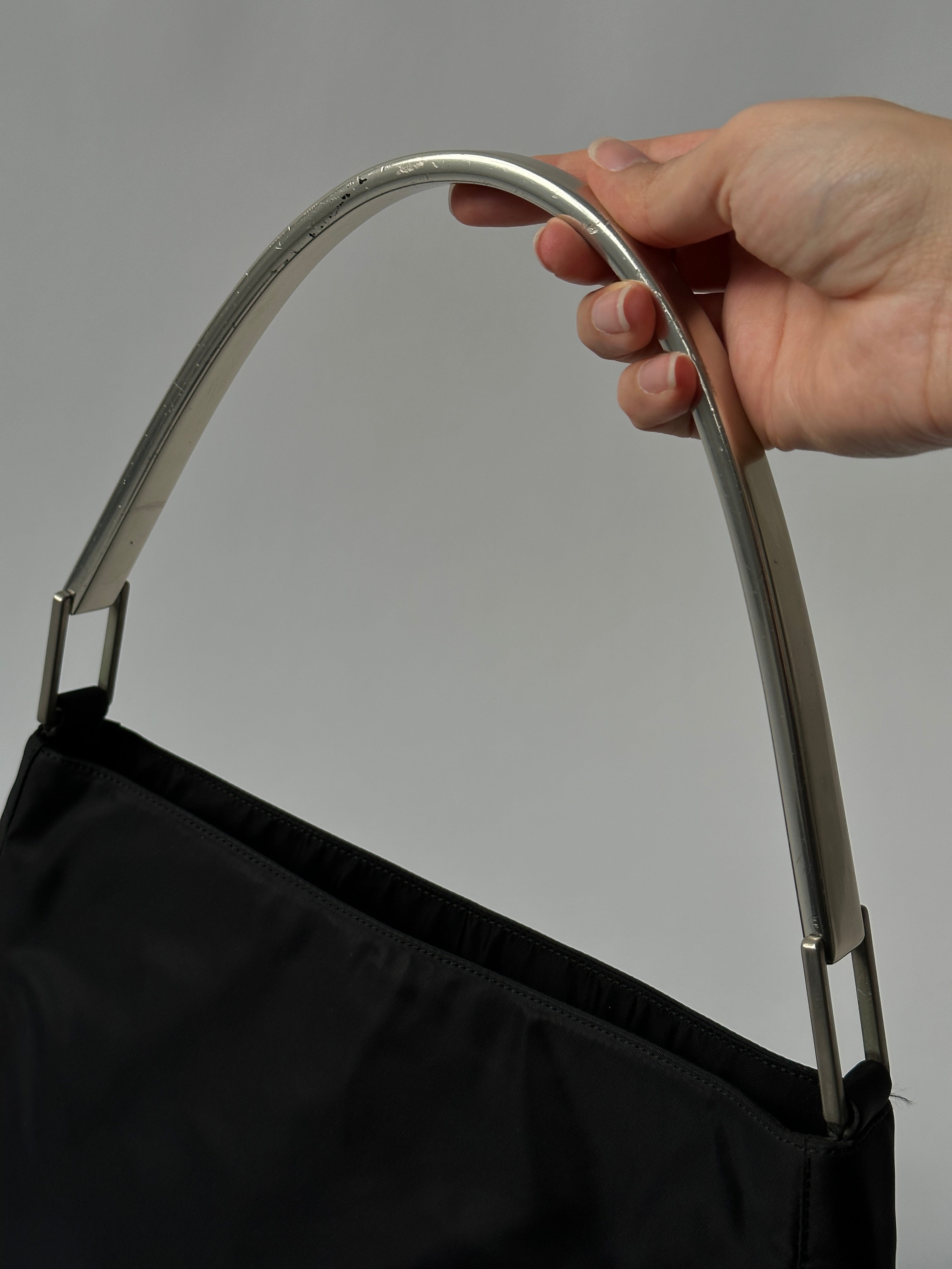 Prada Nylon Shoulder Bag with metal handle, black and sleek design, featuring the signature Prada logo and durable nylon material.