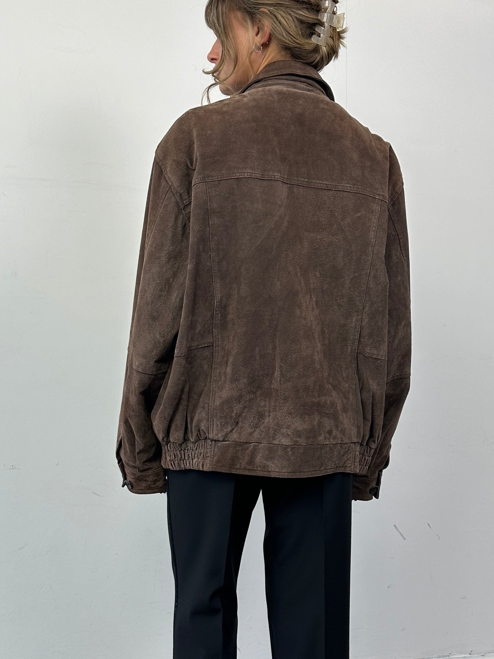 Vintage suede leather bomber jacket in size large, featuring classic design with a soft, textured finish and ribbed collar and cuffs.