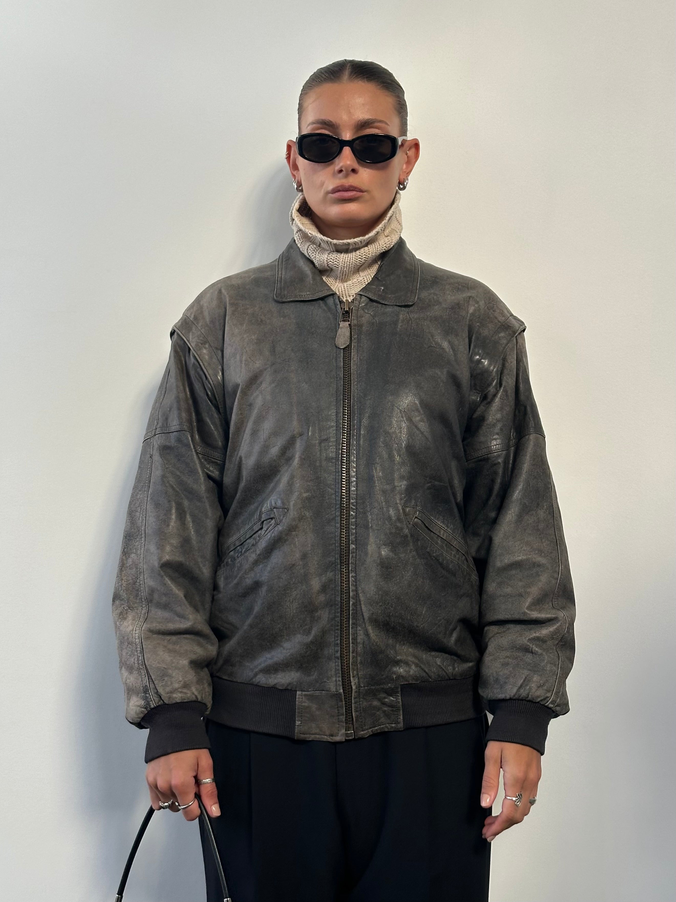 Vintage distressed leather bomber jacket in size L/XL, featuring rugged design and classic style.