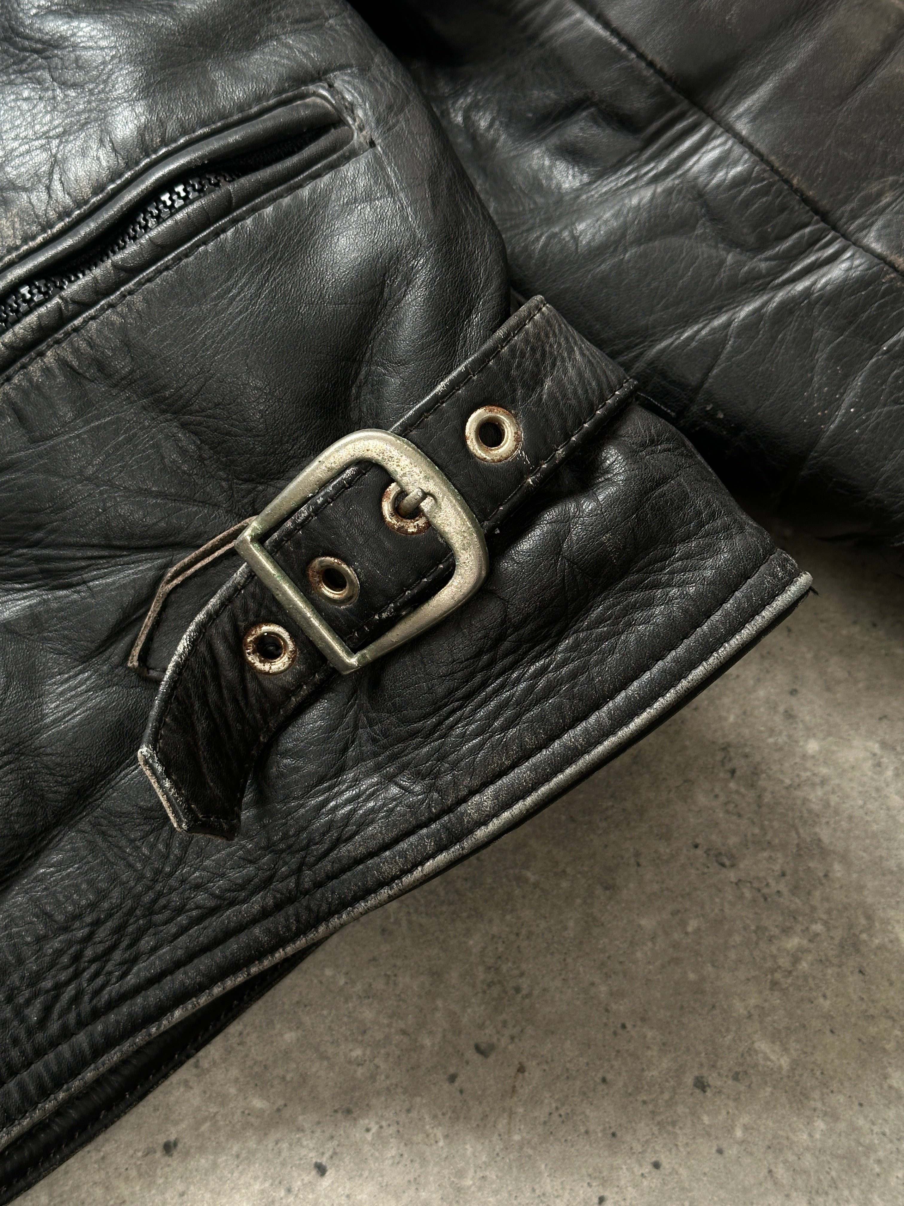Vintage distressed motorcycle leather jacket in size L/XL, featuring rugged design and classic styling.