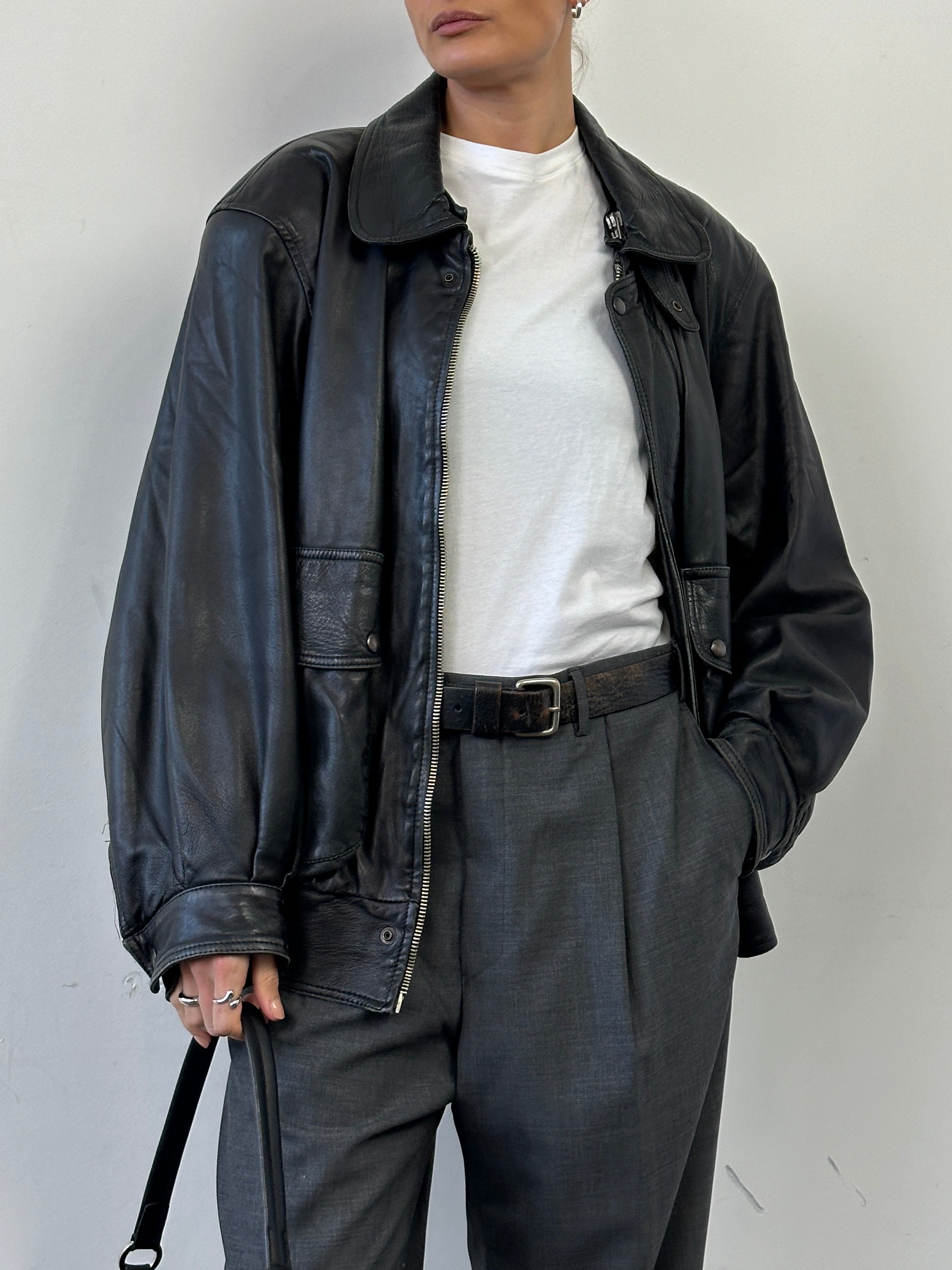 Vintage leather bomber jacket in M/L size, featuring classic design with ribbed cuffs and collar, worn by a model.
