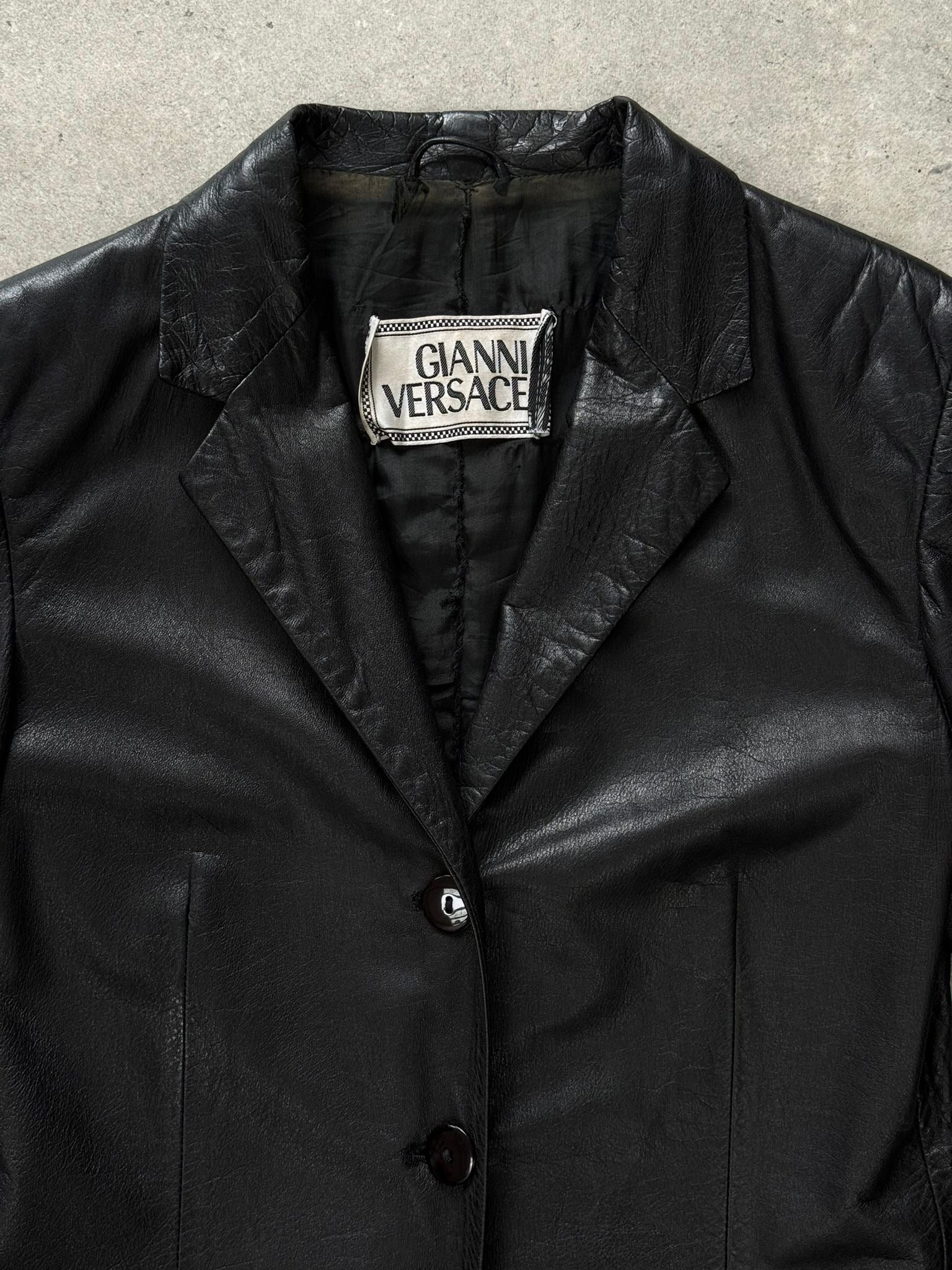 Versace 1990s fitted leather jacket in XS, stylish black leather jacket with classic design and detailed stitching.
