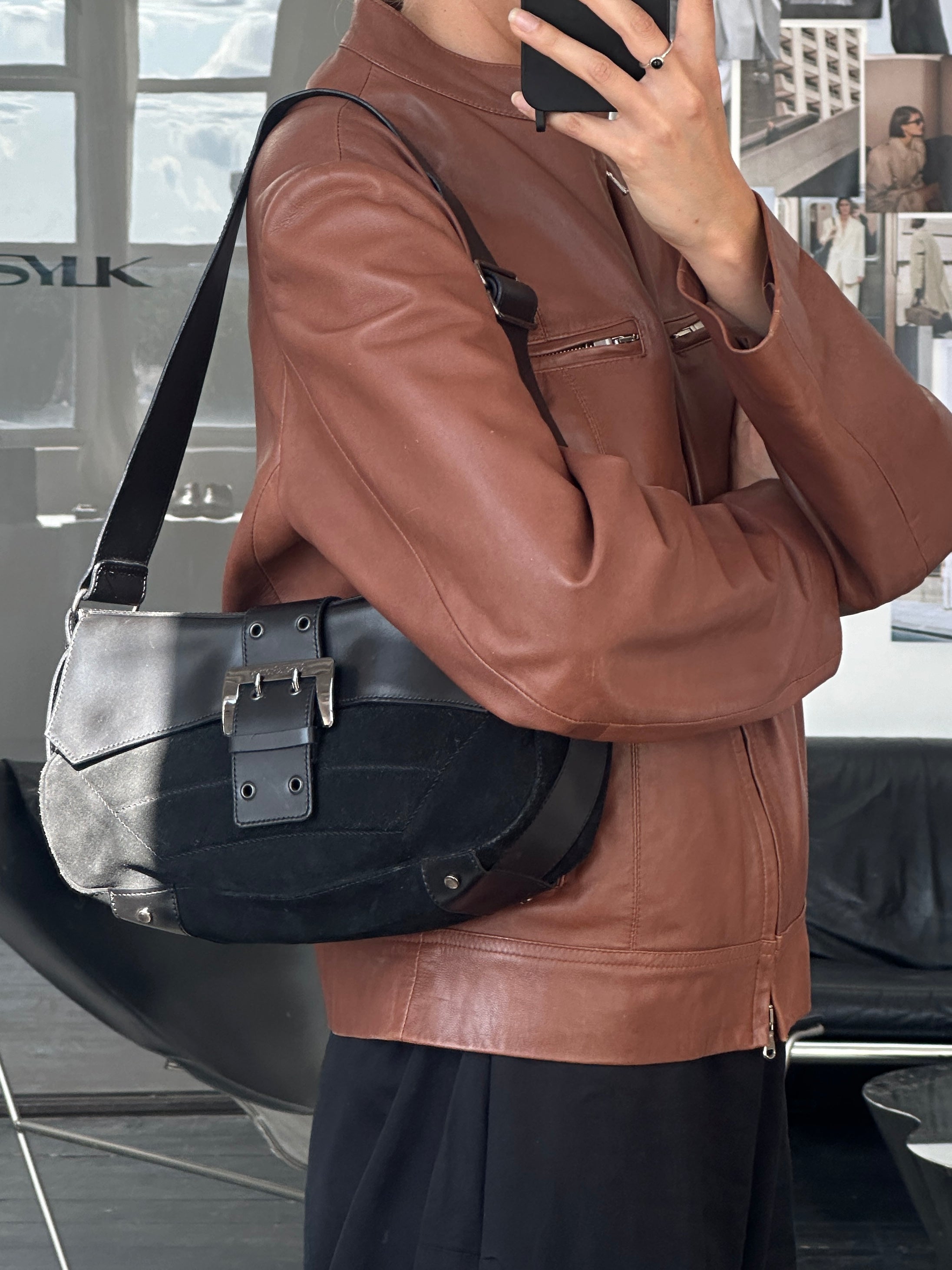 Vintage Russell & Bromley 00s leather suede shoulder bag with sleek design and adjustable strap, displayed on a plain background.