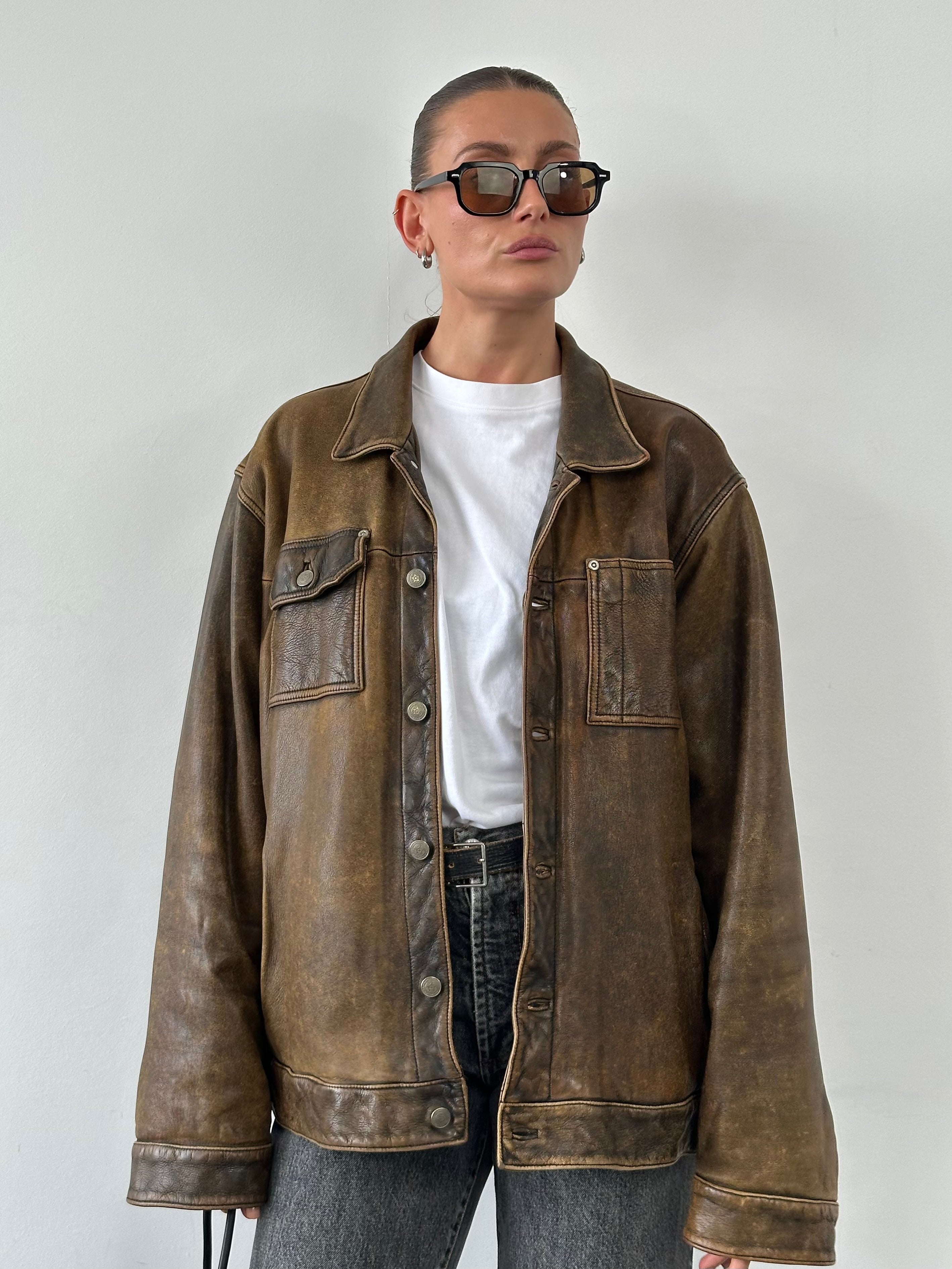 Vintage aged leather trucker jacket in XL size, showing classic distressed leather and rugged collar detail.