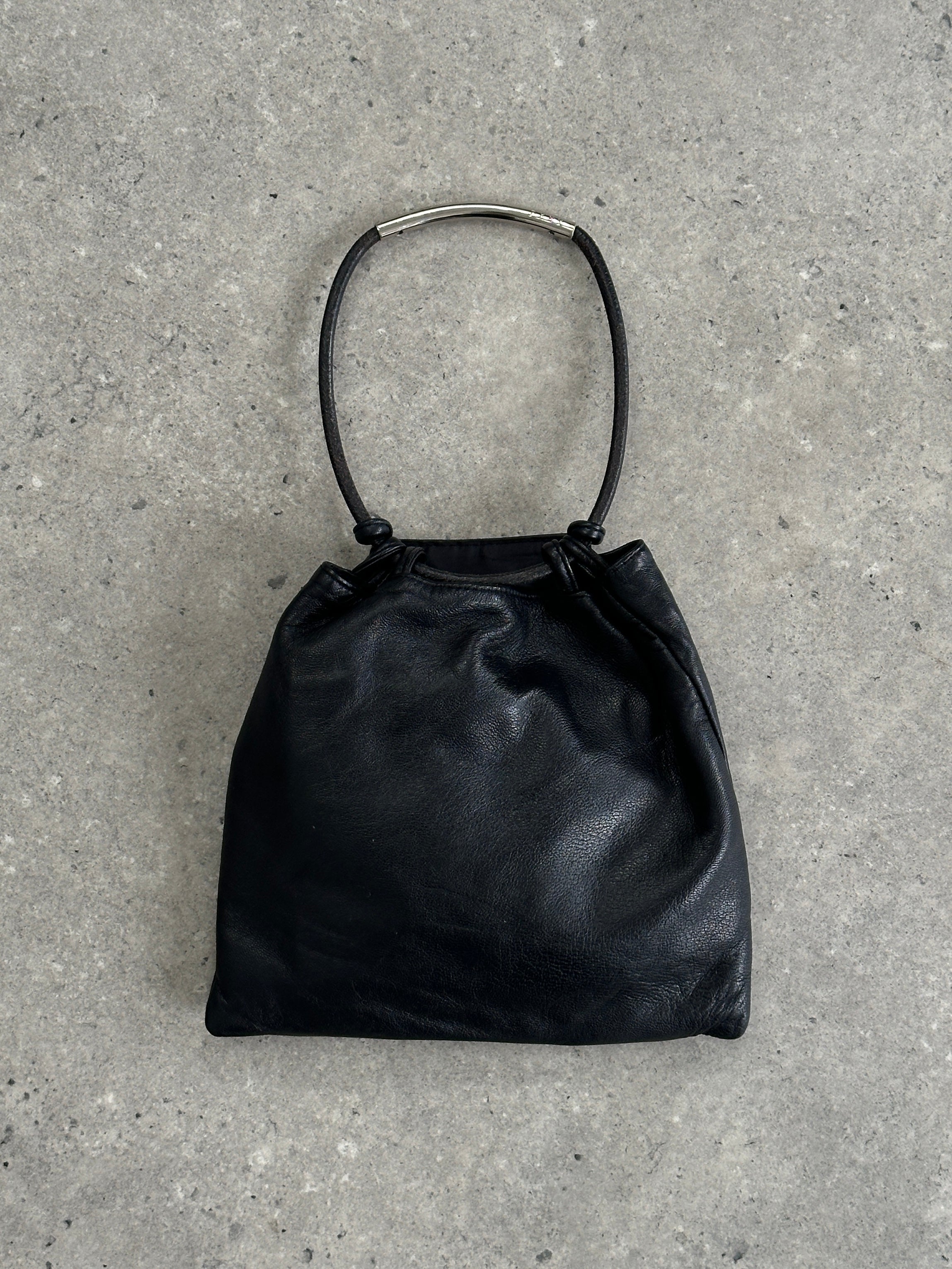 DKNY soft leather clutch bag with sleek design and minimal detailing, perfect for evening or formal occasions.