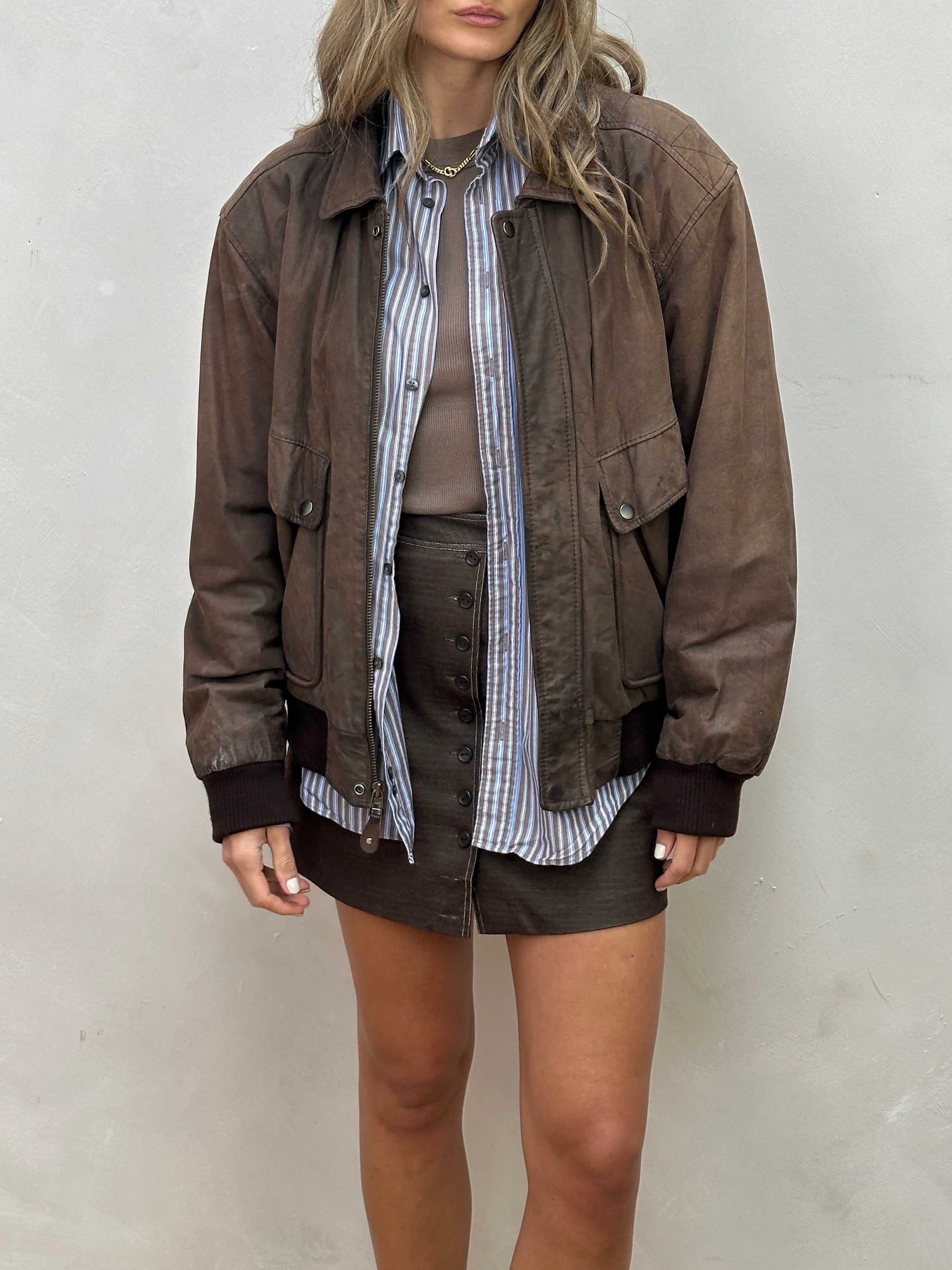 Vintage distressed leather bomber jacket in size large, featuring rugged design and classic style.