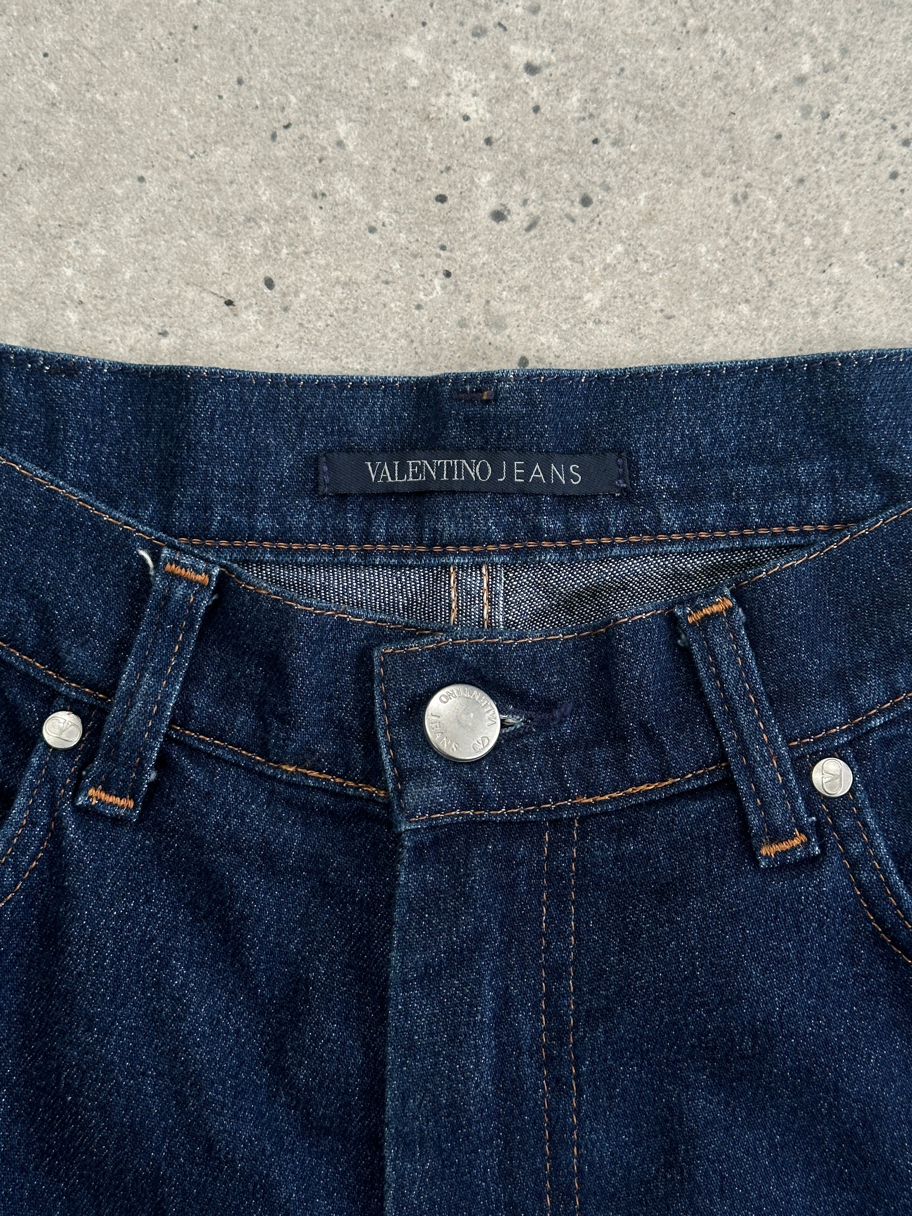 Valentino high waisted straight leg denim jeans in dark blue, front view showing classic five-pocket design and belt loops.