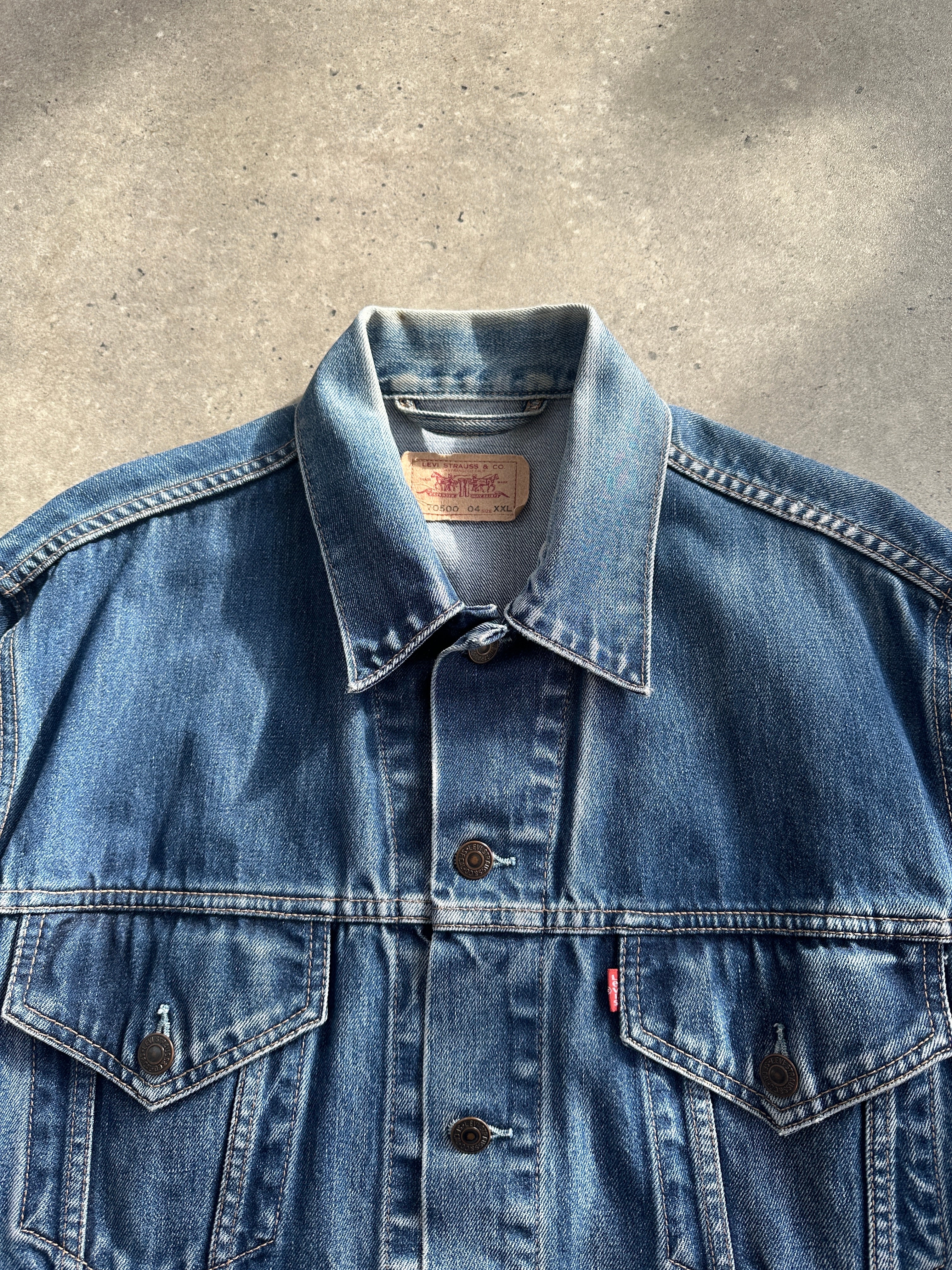 Levi’s faded denim jacket in size L, featuring classic styling and distressed denim texture.