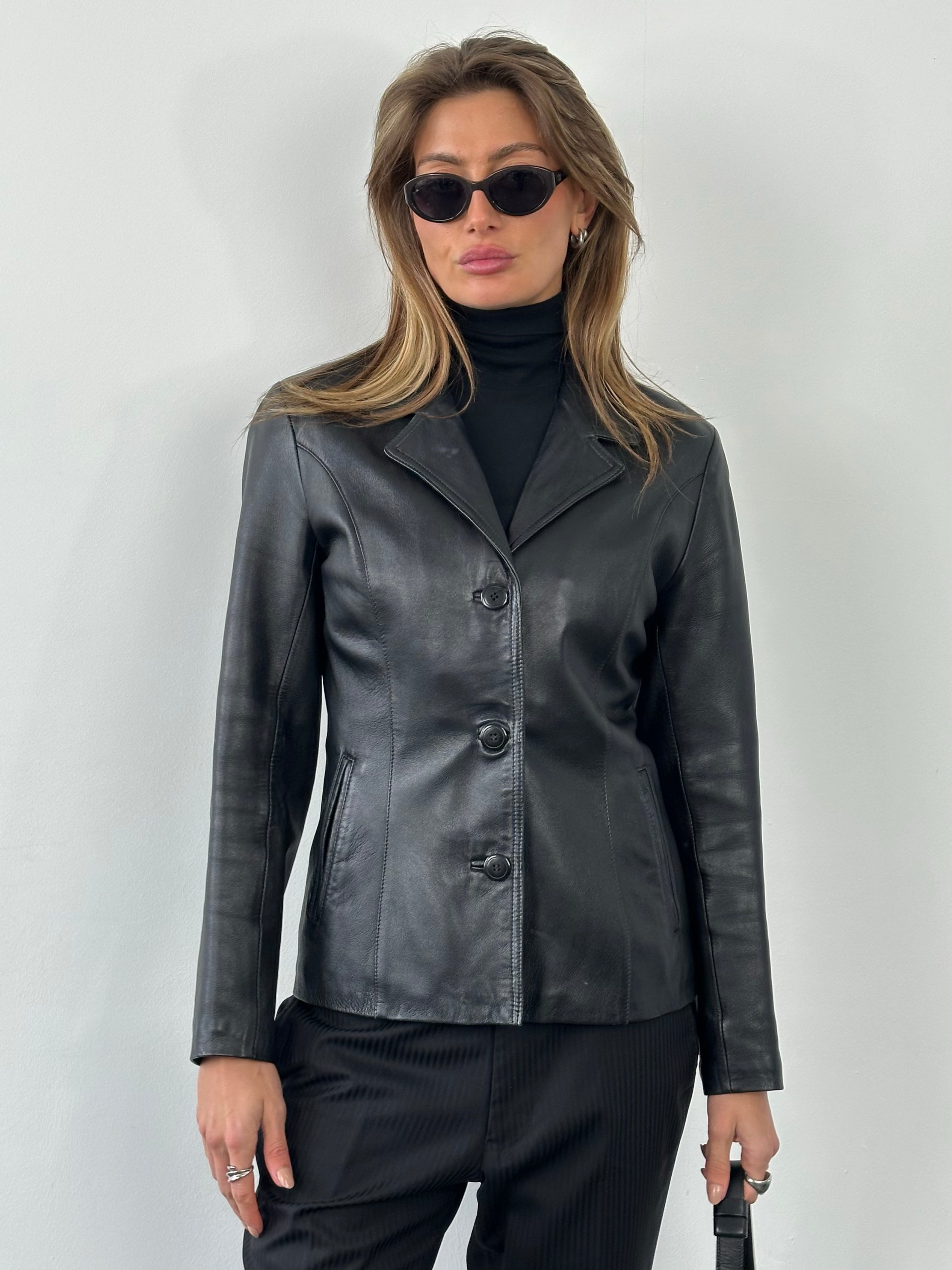 Vintage 1990s leather fitted jacket, stylish and well-crafted, shown on a mannequin with classic leather details.