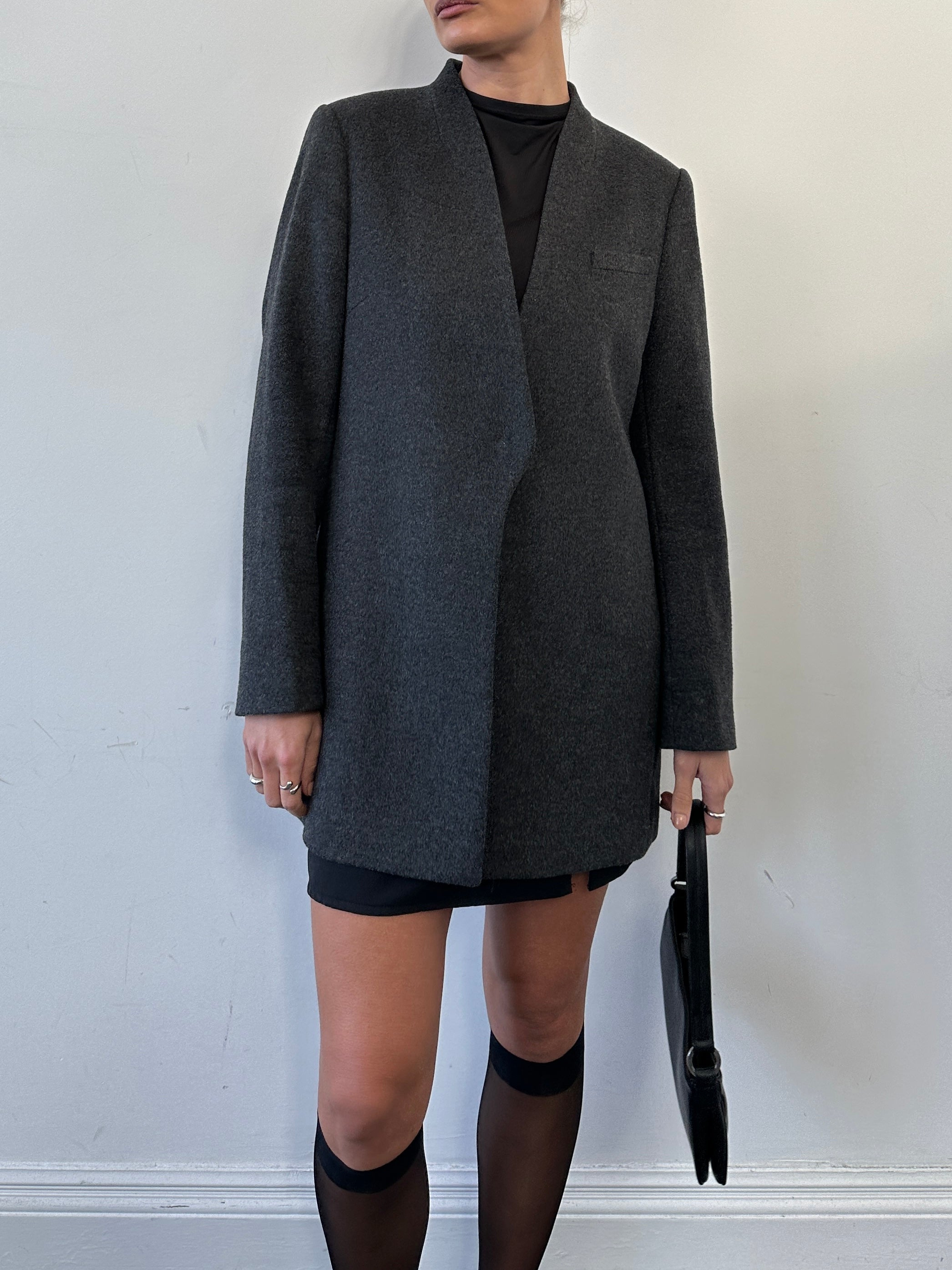 Jaeger minimal wool cashmere coat in size M, showcasing a sleek, tailored design with a classic collar and smooth fabric texture.