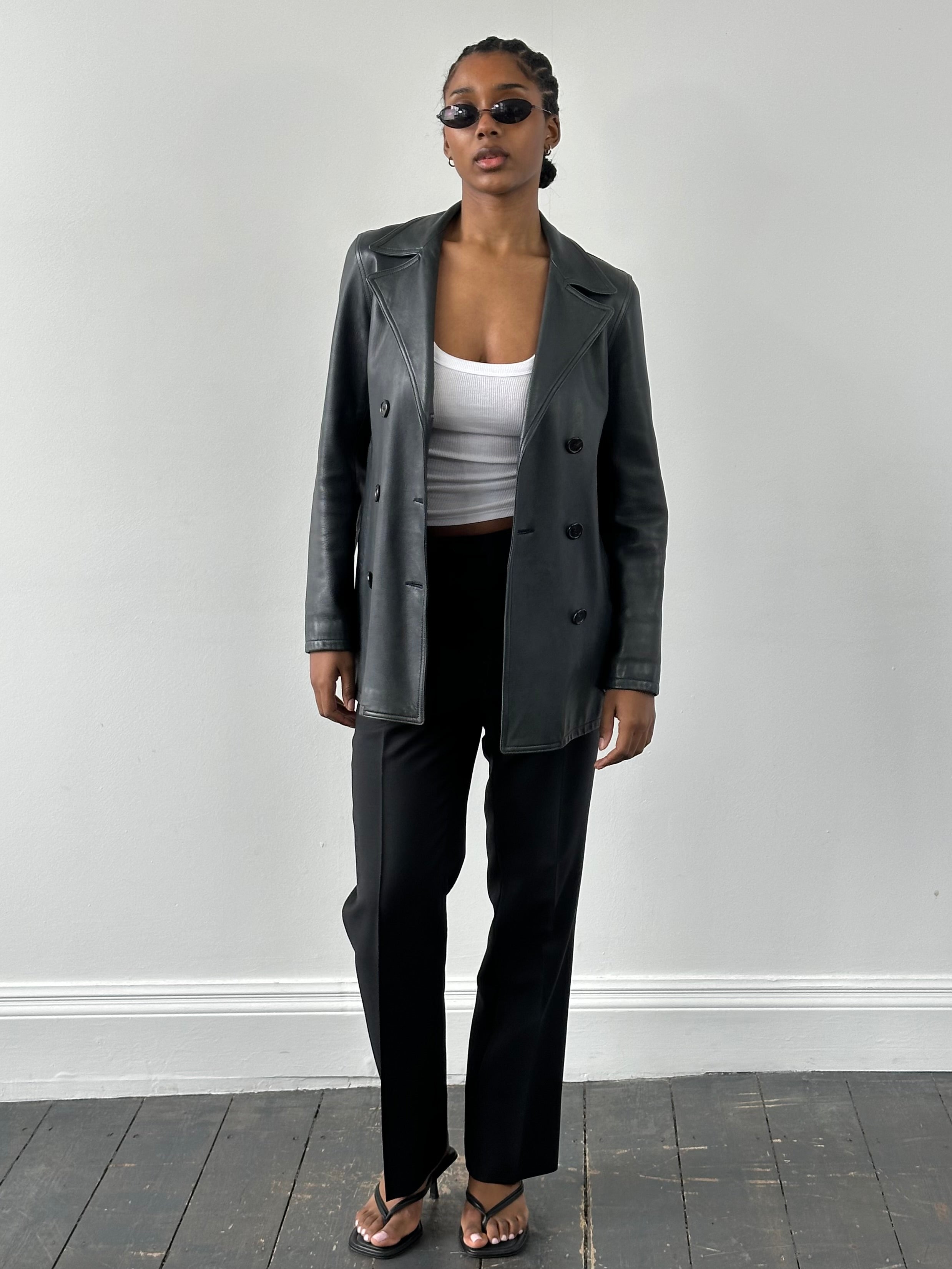 Jaeger 2000s double-breasted leather jacket in black, featuring classic design and tailored fit, displayed on a hanger.