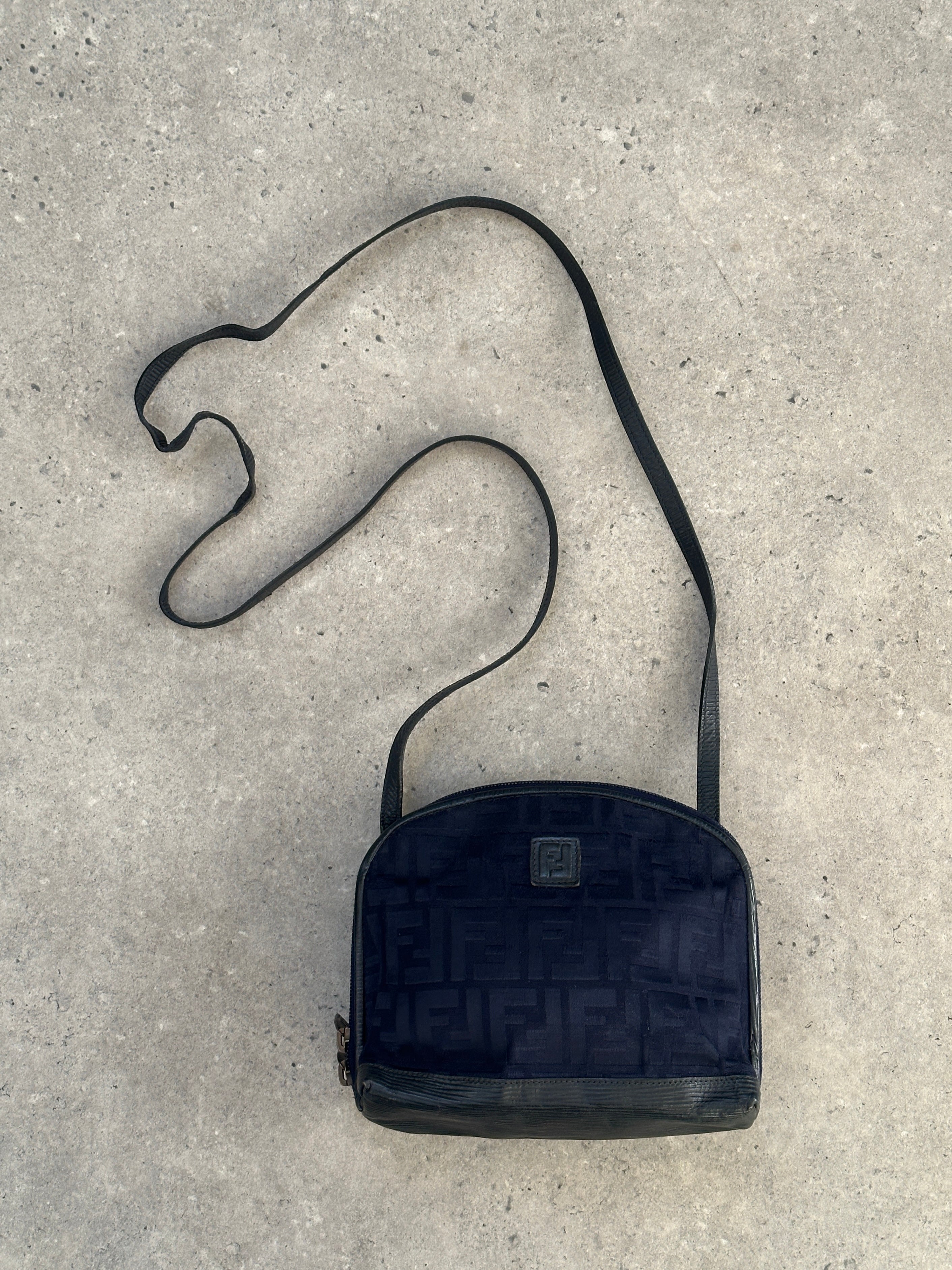 Fendi FF Monogram crossbody bag showing the signature logo pattern, adjustable strap, and sleek design.