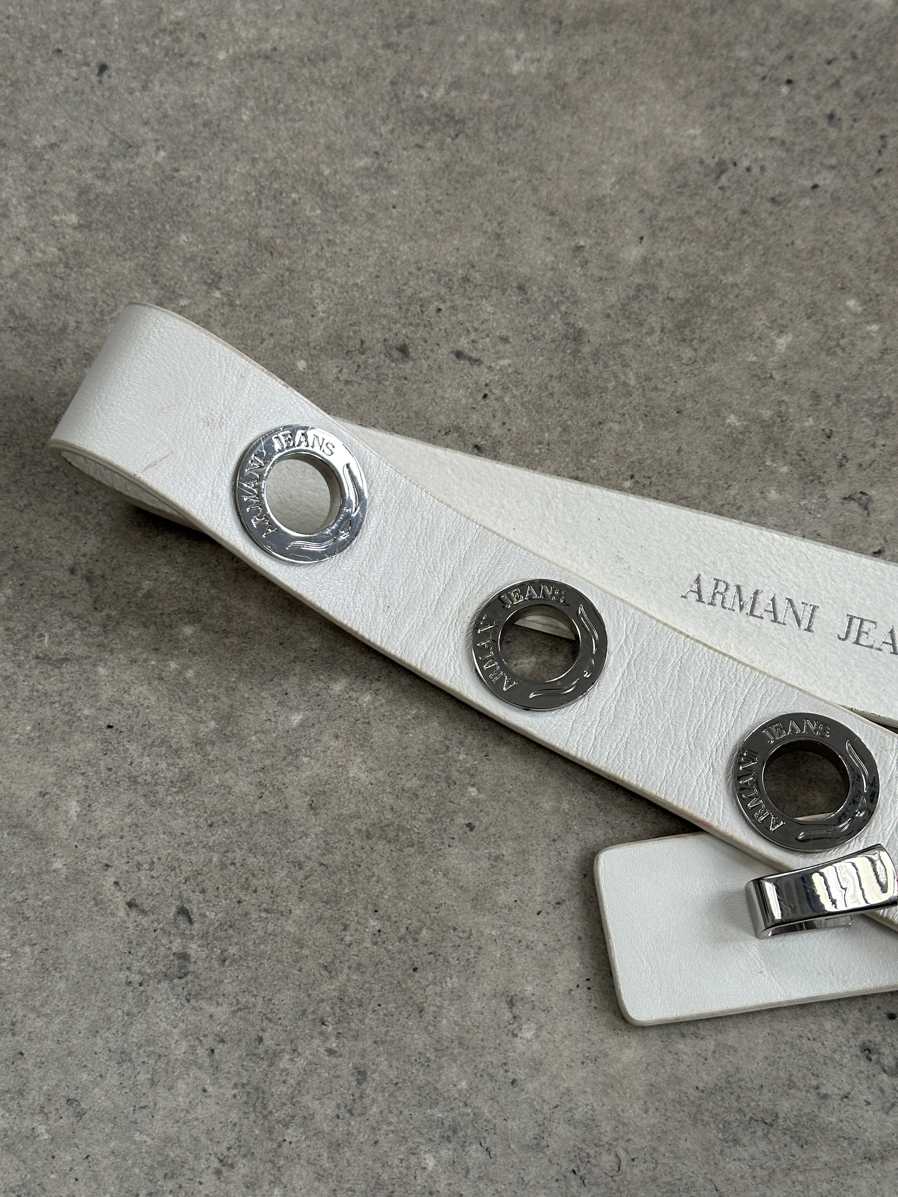 Armani Jeans silver leather belt with eyelet logo buckle and adjustable W26-32, 1990s style accessory.