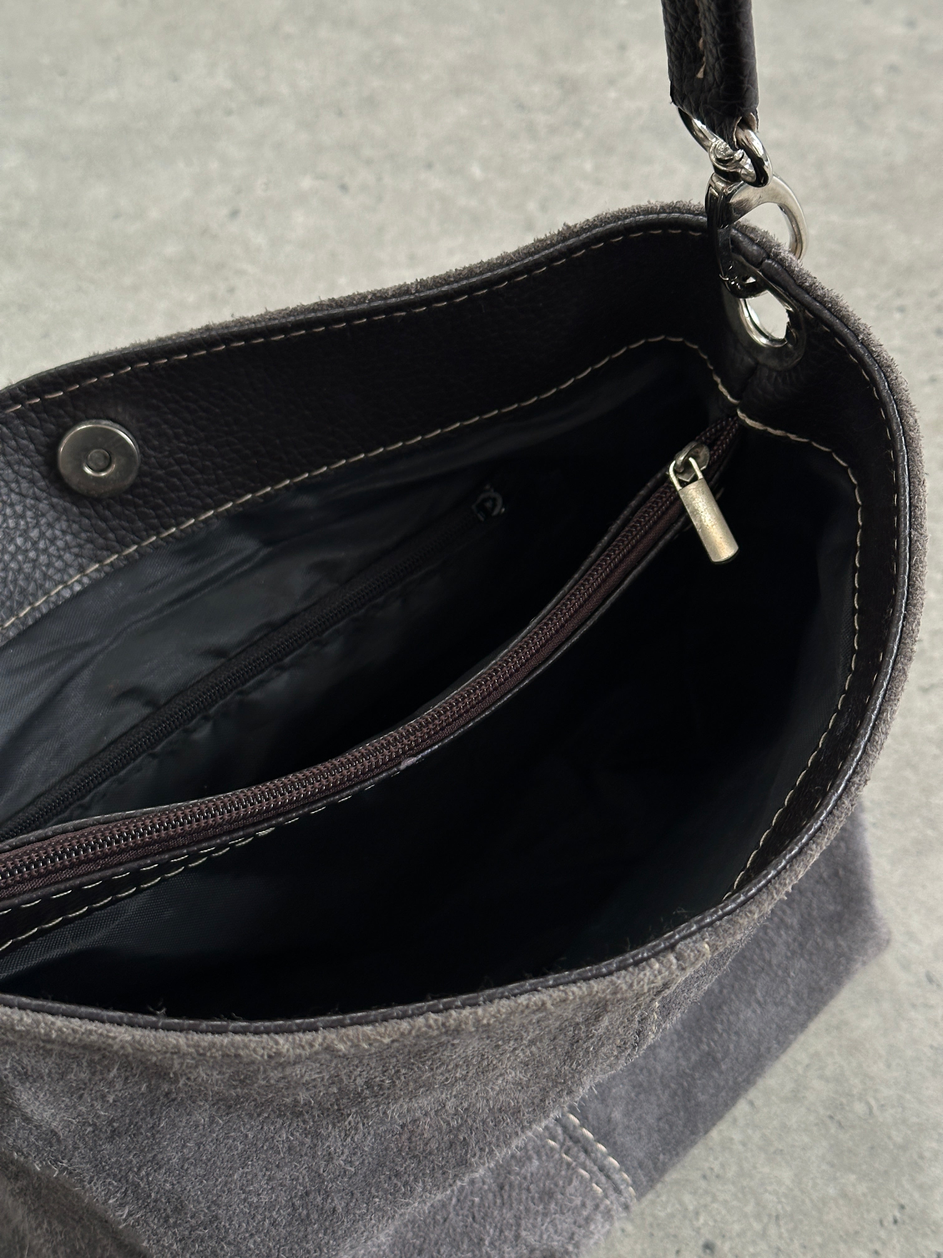 Vintage suede leather shoulder bag with a classic design, featuring a sturdy strap and soft textured surface.