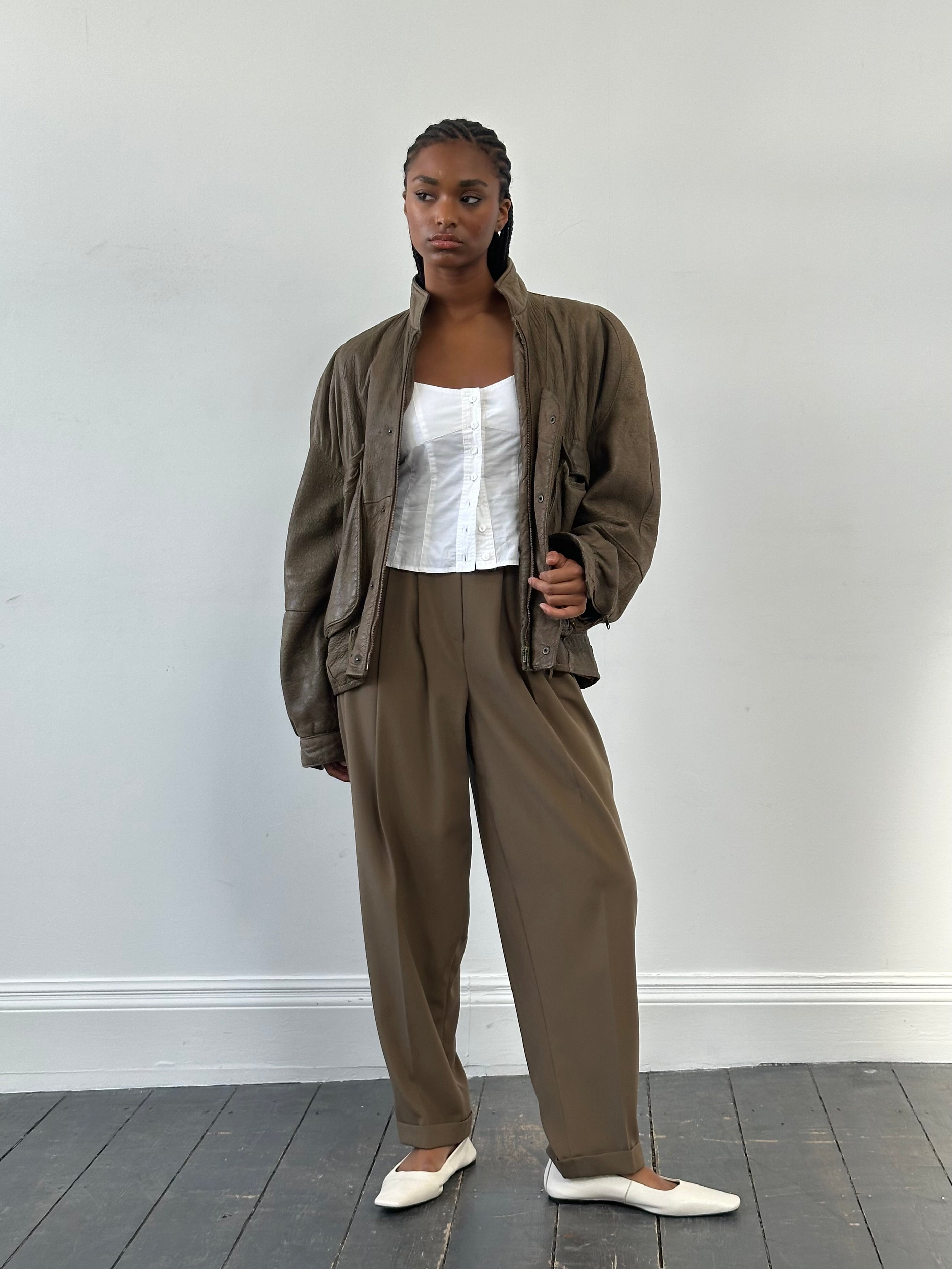 Vintage 1990s high waisted pleated tailored trousers in W28, showcasing classic design and beige fabric with sharp creases.