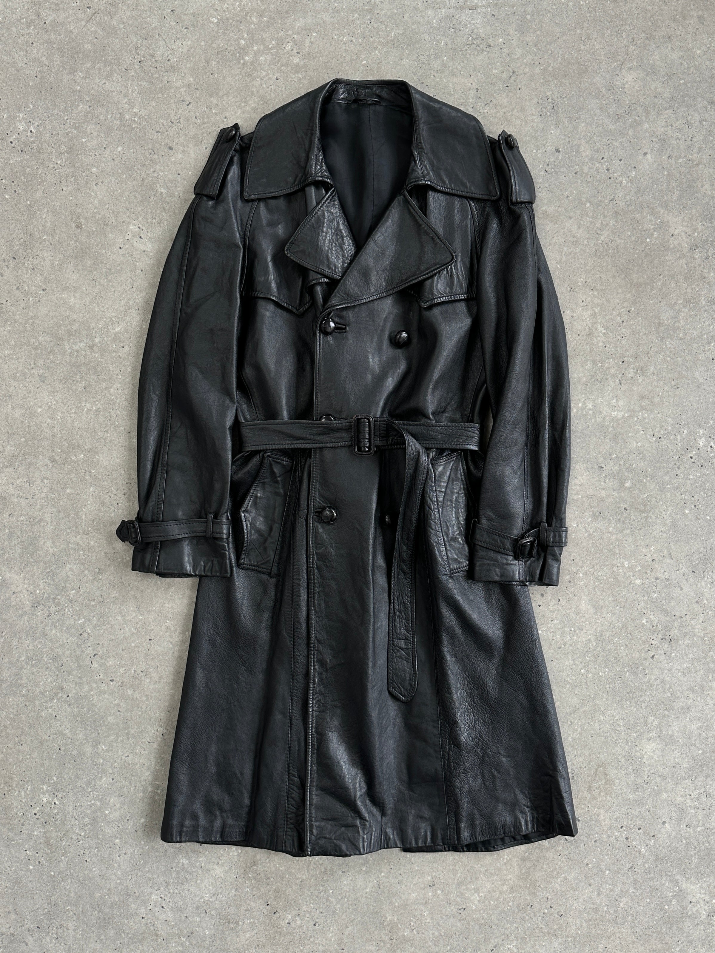 Vintage leather double-breasted belted trench coat, 1960s style, with classic lapels and tailored fit, in a timeless leather jacket design.