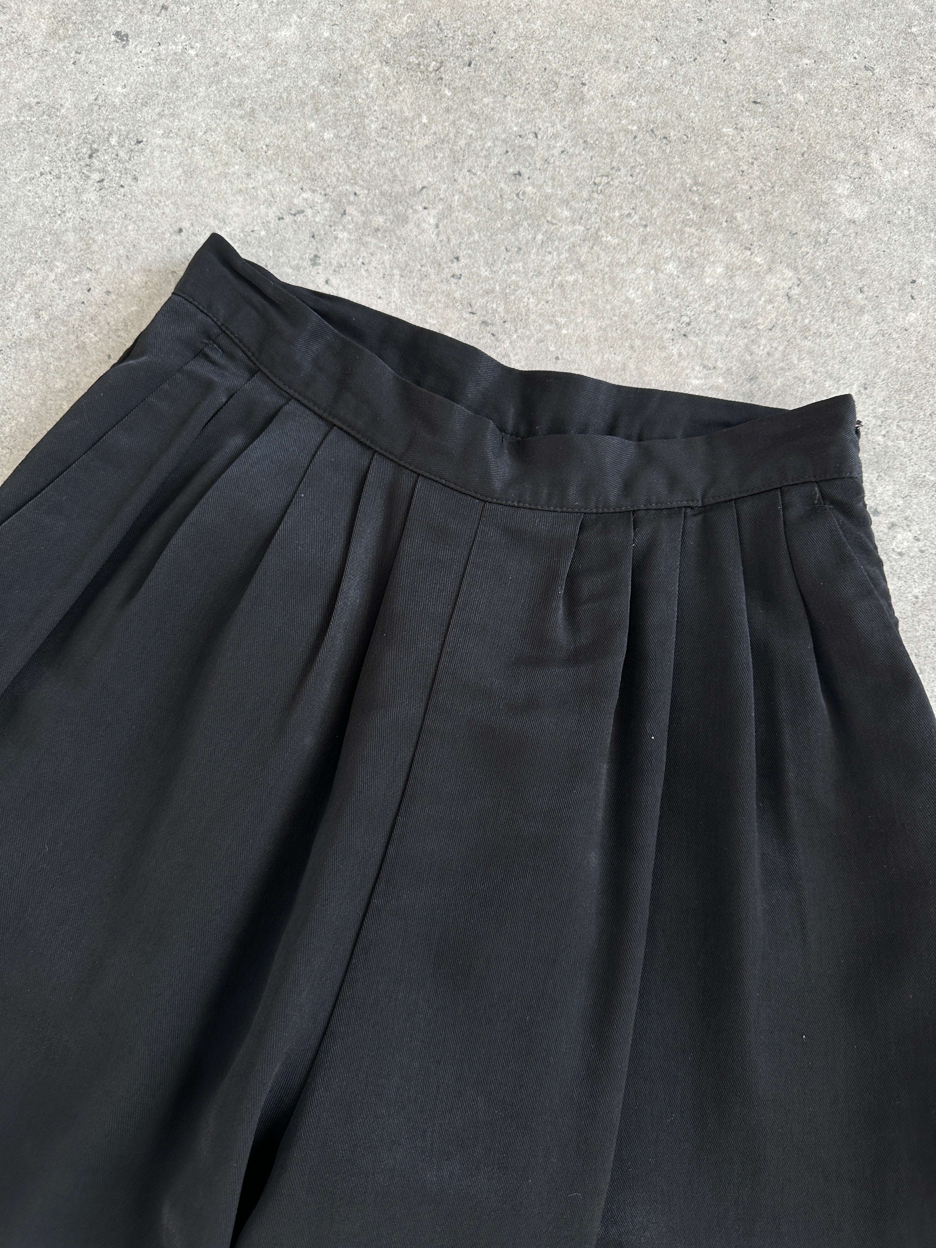 Vintage 1990s wide-leg pleated culottes shorts in W24, featuring high waist and flowing fabric, styled as retro vintage fashion.