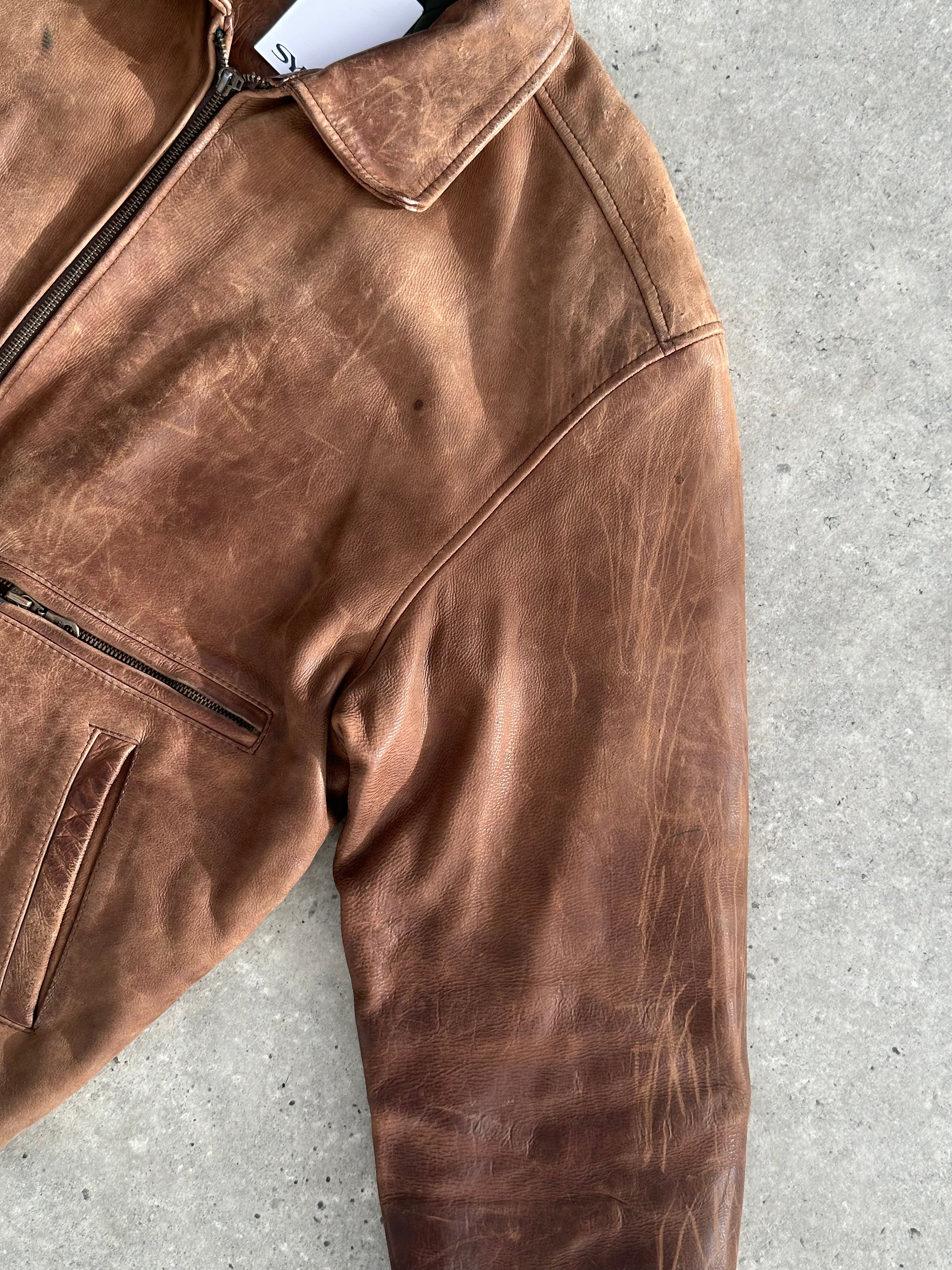 Vintage distressed leather bomber jacket in XL size with a rugged, worn-in look, featuring classic design details.
